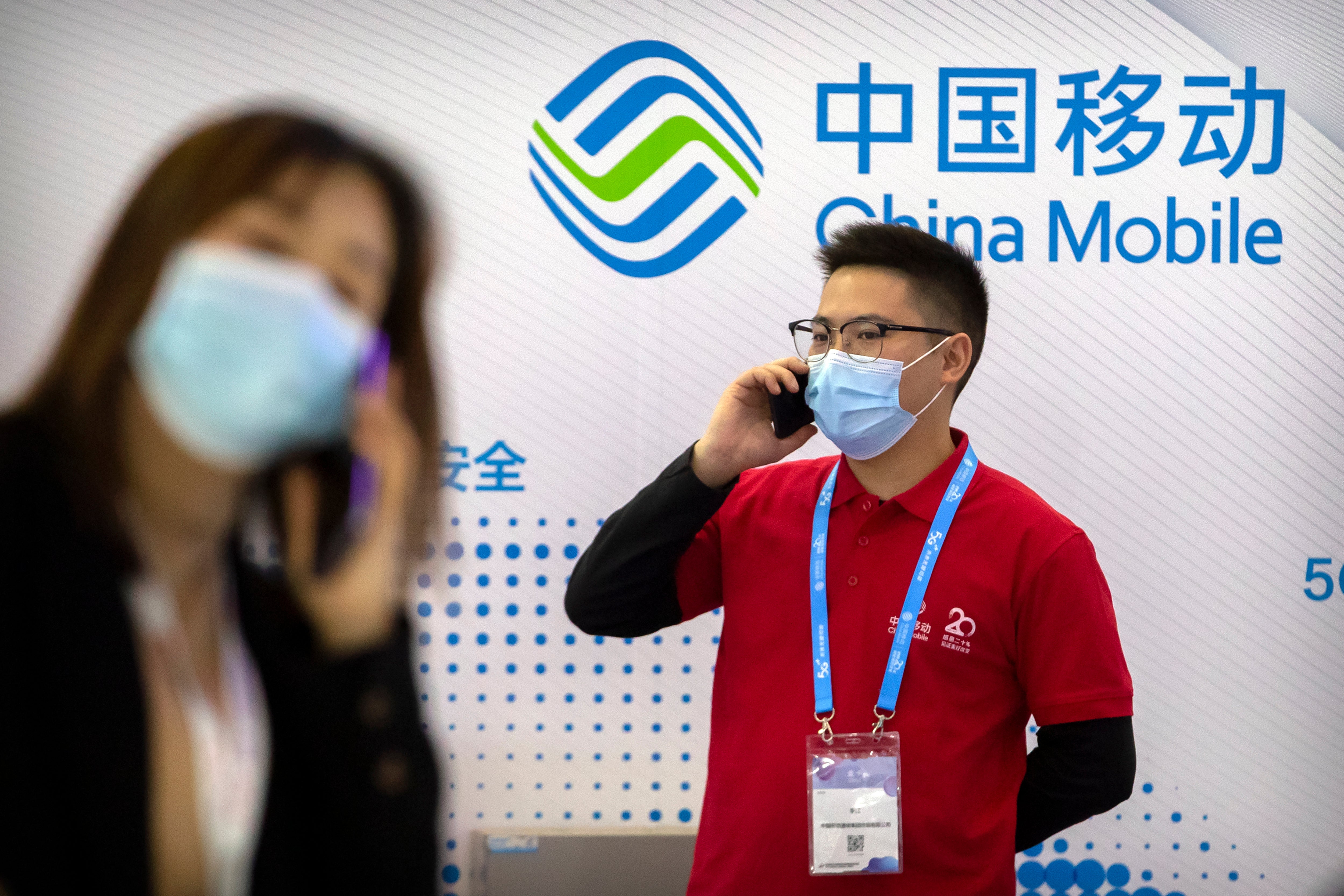 Unas personas cerca de un exhibidor de la empresa china de telecomunicaciones China Mobile en la PT Expo en Beijing, el 14 de octubre de 2020.&nbsp;