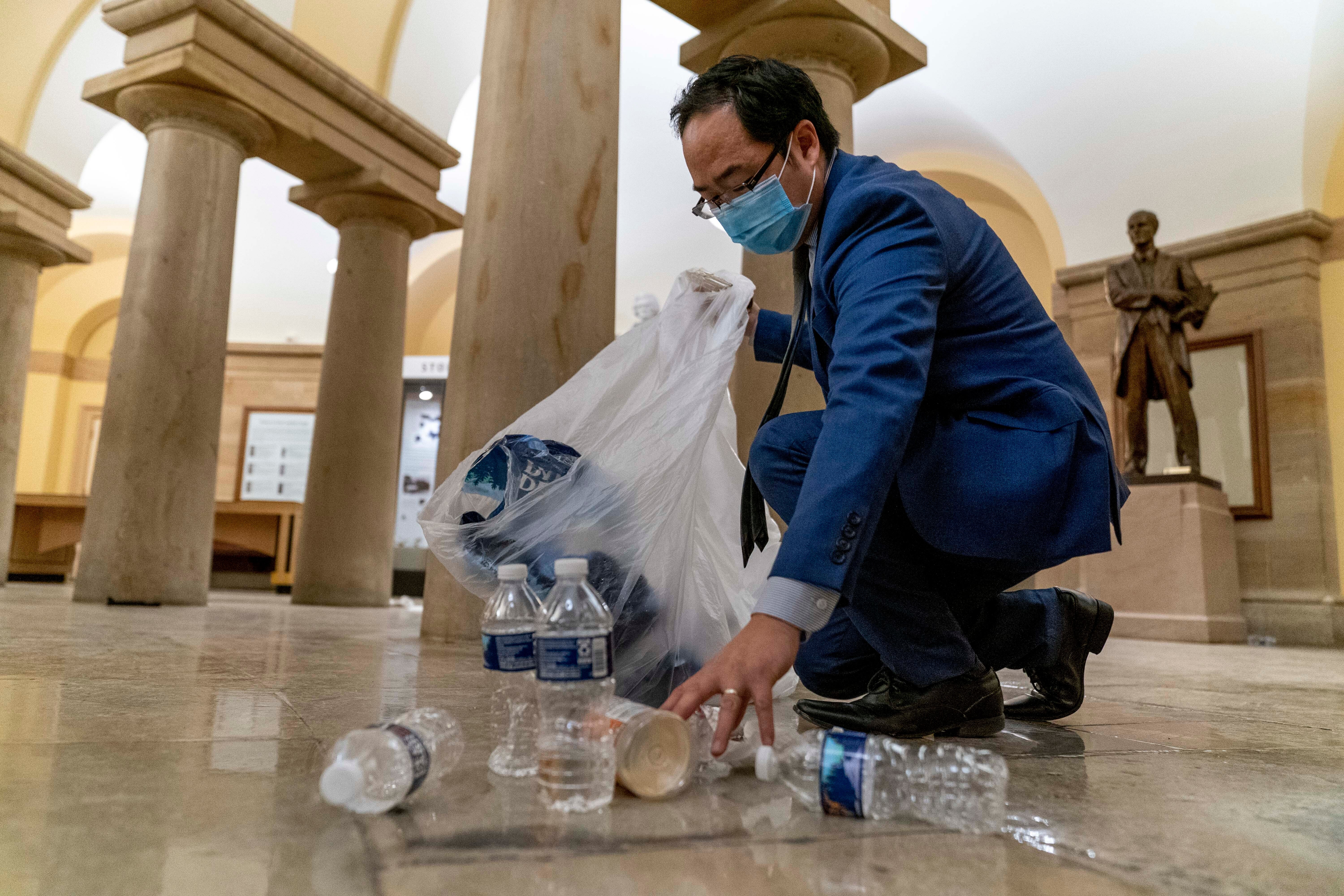 El representante Andy Kim limpia los escombros y la basura en la mañana del 7 de enero del 2021 después de que la multitud asedió el Capitolio