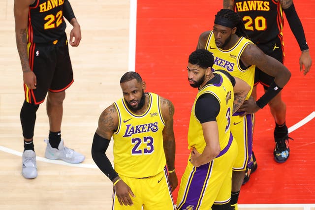 LeBron James de Los Angeles Lakers reacciona a un fan en la cancha durante la segunda mitad contra los Atlanta Hawks en State Farm Arena