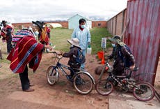 Estudiantes bolivianos regresan a clases enfundados en trajes protectores y con cubrebocas