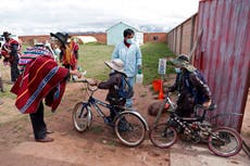 Estudiantes bolivianos regresan a clases enfundados en trajes protectores y con cubrebocas
