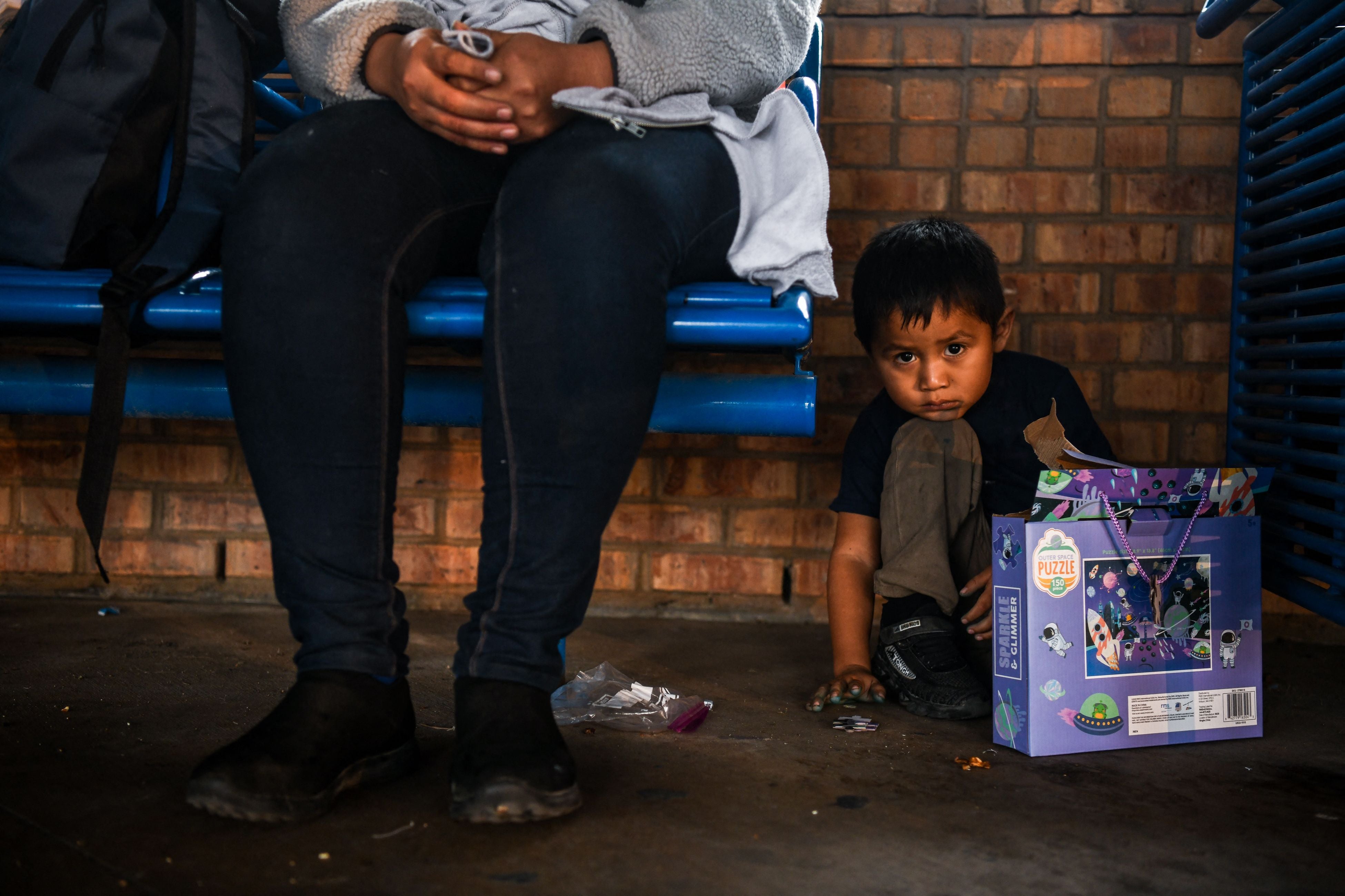 Cientos de hombres, mujeres y niños esperan sentados en la estación de autobuses de Brownsville