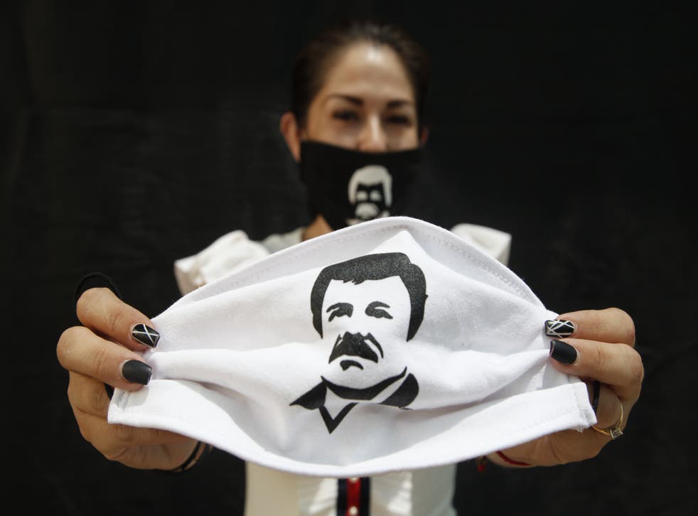 Una mujer muestra un cubrebocas con la imagen de Joaquín “El Chapo” Guzmán  Loera, el 16 de abril de 2020 en Guadalajara, Jalisco. 