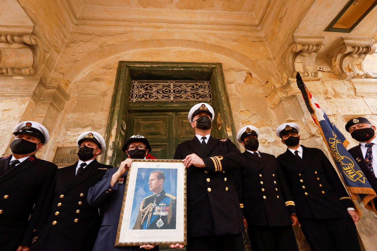 Los miembros recreadores del Grupo de Historia Viva del Comando de Malta de la Segunda Guerra Mundial y ex oficial de la WREN de la Marina Real Elaine Zerafa, Secretaria de la Asociación Naval Real (Rama de Malta) sostienen una foto del Príncipe Felipe para honrarlo antes de su funeral, en las afueras de Villa Guardamangia, una antigua residencia de La entonces princesa Isabel y el príncipe Felipe de Gran Bretaña entre 1949 y 1951, en Pieta, Malta