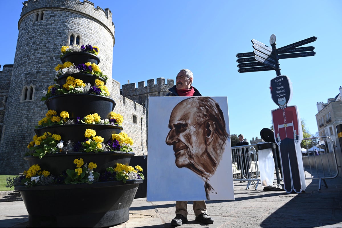 Artista Kaya Marr sostiene un retrato del Príncipe Felipe de Gran Bretaña fuera del Castillo de Windsor en Windsor