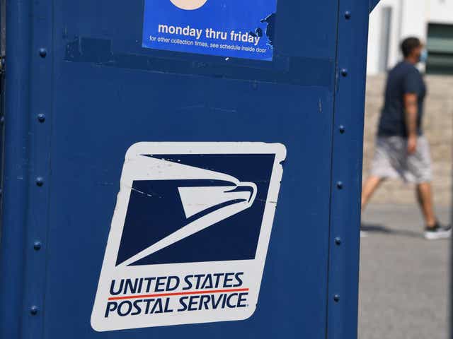 Un hombre pasa junto a un buzón de correo frente a una oficina de correos en los Ángeles, California, el 17 de agosto de 2020