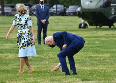 Joe Biden se detiene para recoger un diente de león para la primera dama mientras caminan hacia Marine One para viajar a Georgia