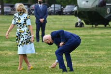 Joe Biden se detiene para recoger un diente de león para la primera dama mientras caminan hacia Marine One para viajar a Georgia