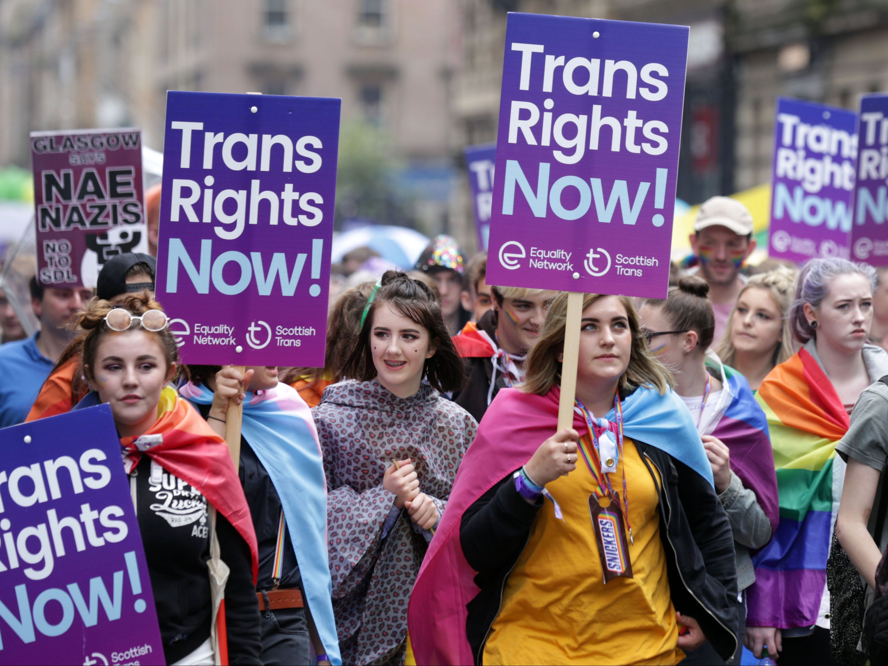 Personas que portan pancartas de derechos trans participan en el desfile del Orgullo en Glasgow