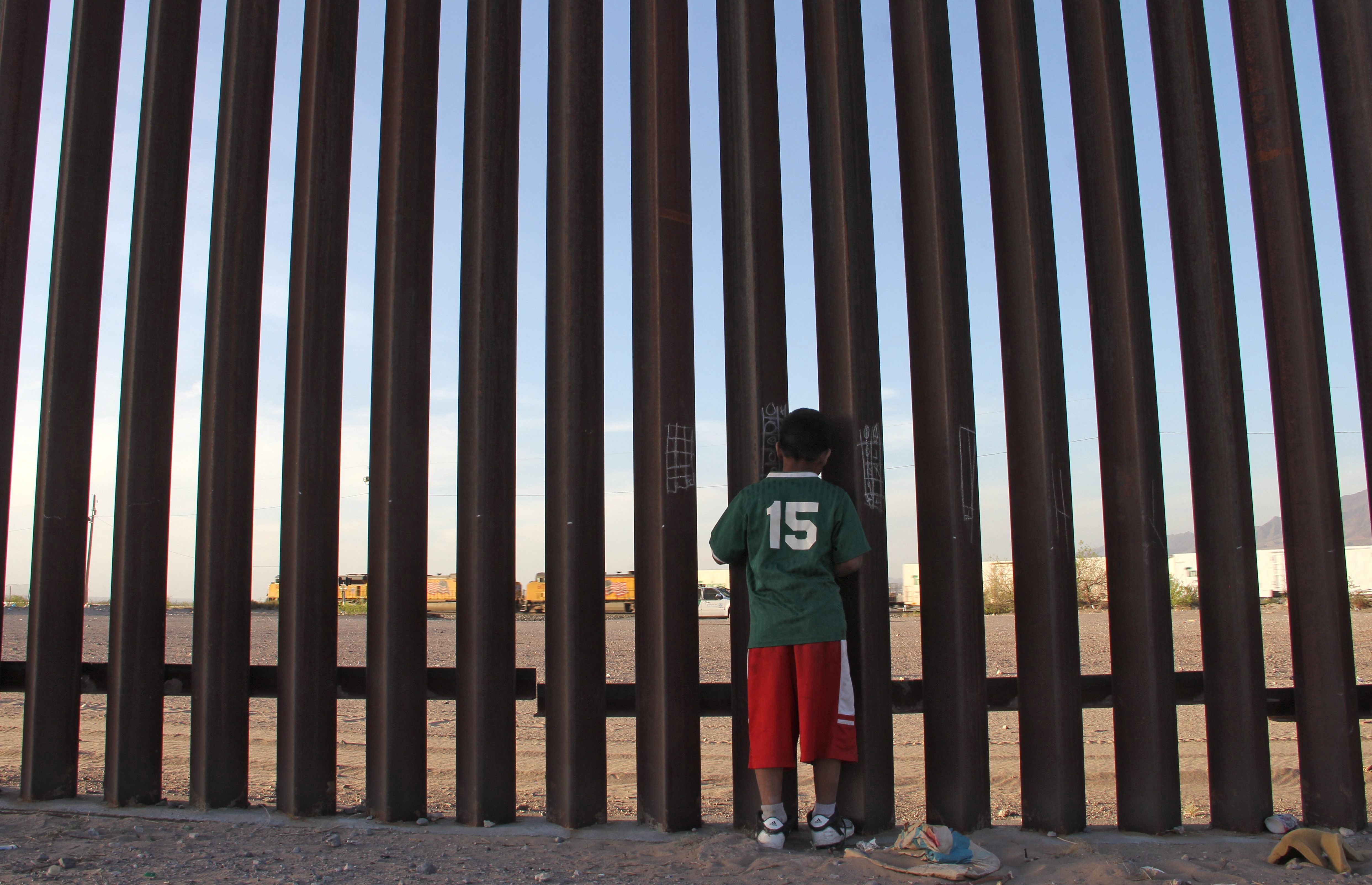 Un niño mexicano mira un vehículo de la patrulla fronteriza de Estados Unidos a través de la valla México-Estados Unidos en Ciudad Juárez, estado de Chihuahua, México, el 4 de abril de 2018. Organizaciones de derechos humanos han instado al gobierno de Estados Unidos a dejar de deportar a niños mexicanos en deportaciones rápidas.