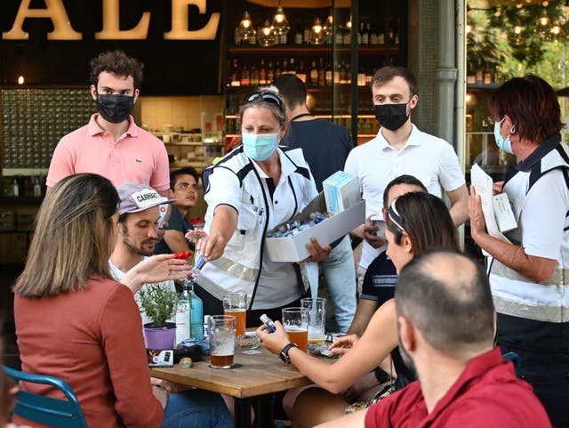 <p>Anti-Covid mediators deliver hand sanitiser to customers on a bar terrace in Strasbourg</p>