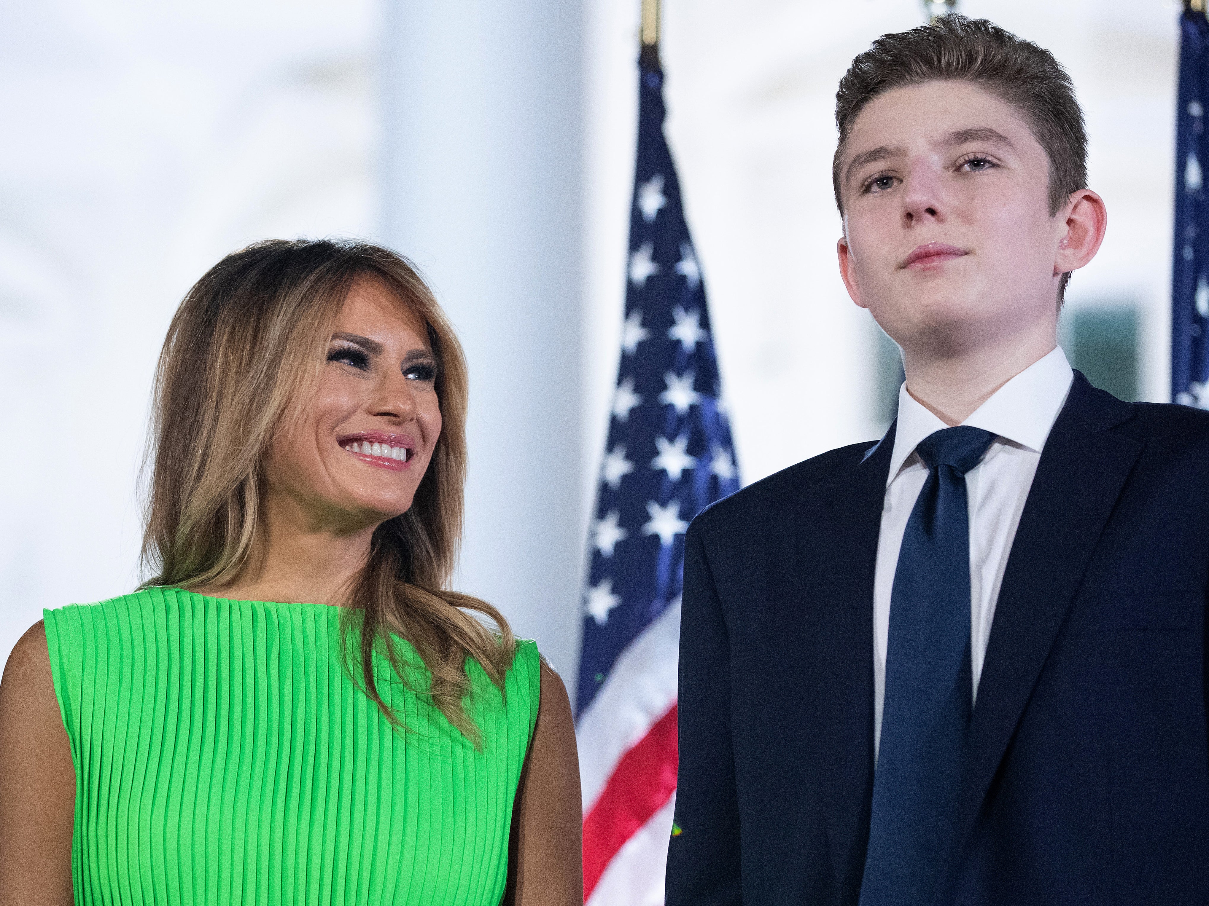 La primera dama Melania Trump (izquierda) mira a su hijo Barron después de que Donald Trump diera su discurso de aceptación de la candidatura presidencial republicana ante 1.500 invitados en la Explanada Sur de la Casa Blanca el 27 de agosto de 2020 en Washington, D. C.