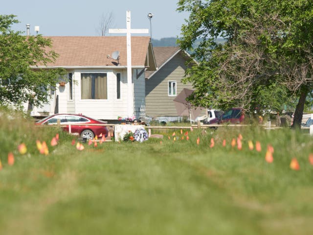 <p>Las banderas marcan el lugar donde los restos de más de 750 niños fueron enterrados en el sitio de la antigua Escuela Residencial Indígena Marieval en Cowessess First Nation, Saskatchewan, 25 de junio de 2021</p>