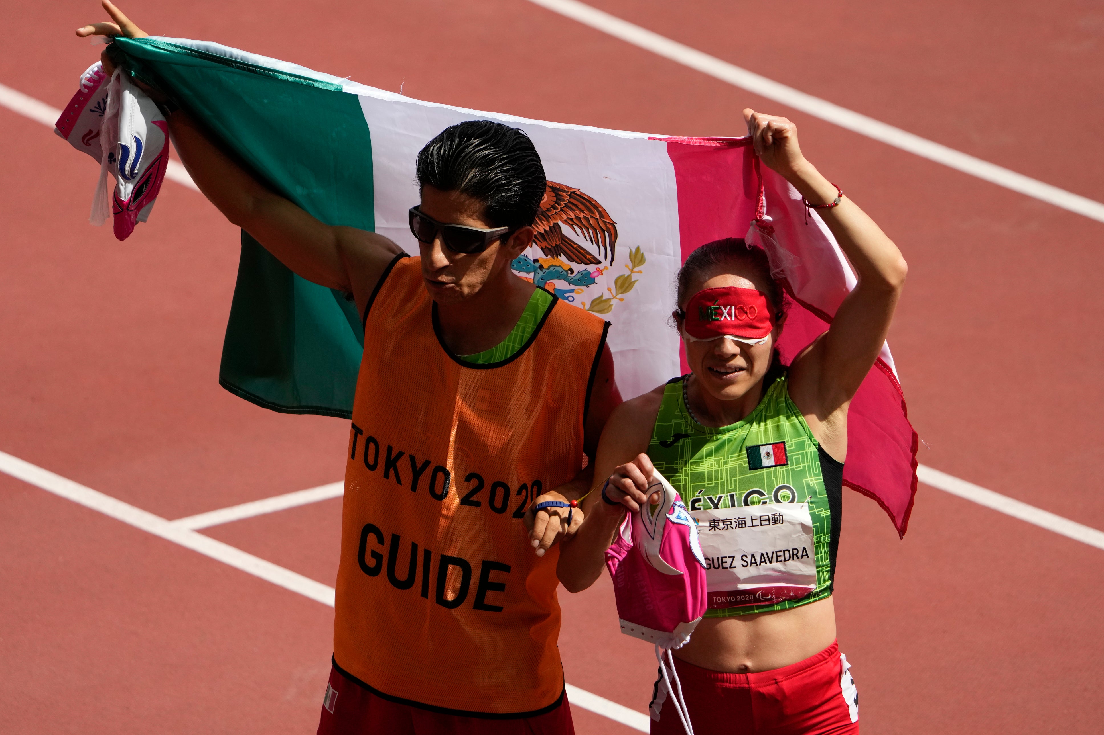 La mexicana Mónica Olivia Rodríguez Saavedra, derecha, y su guía, Kevin Teodoro Aguilar Pérez, celebran durante los 1500m T11 femeninos de los Juegos Paralímpicos de 2020 en el Estadio Nacional de Tokio, el lunes 30 de agosto de 2021.
