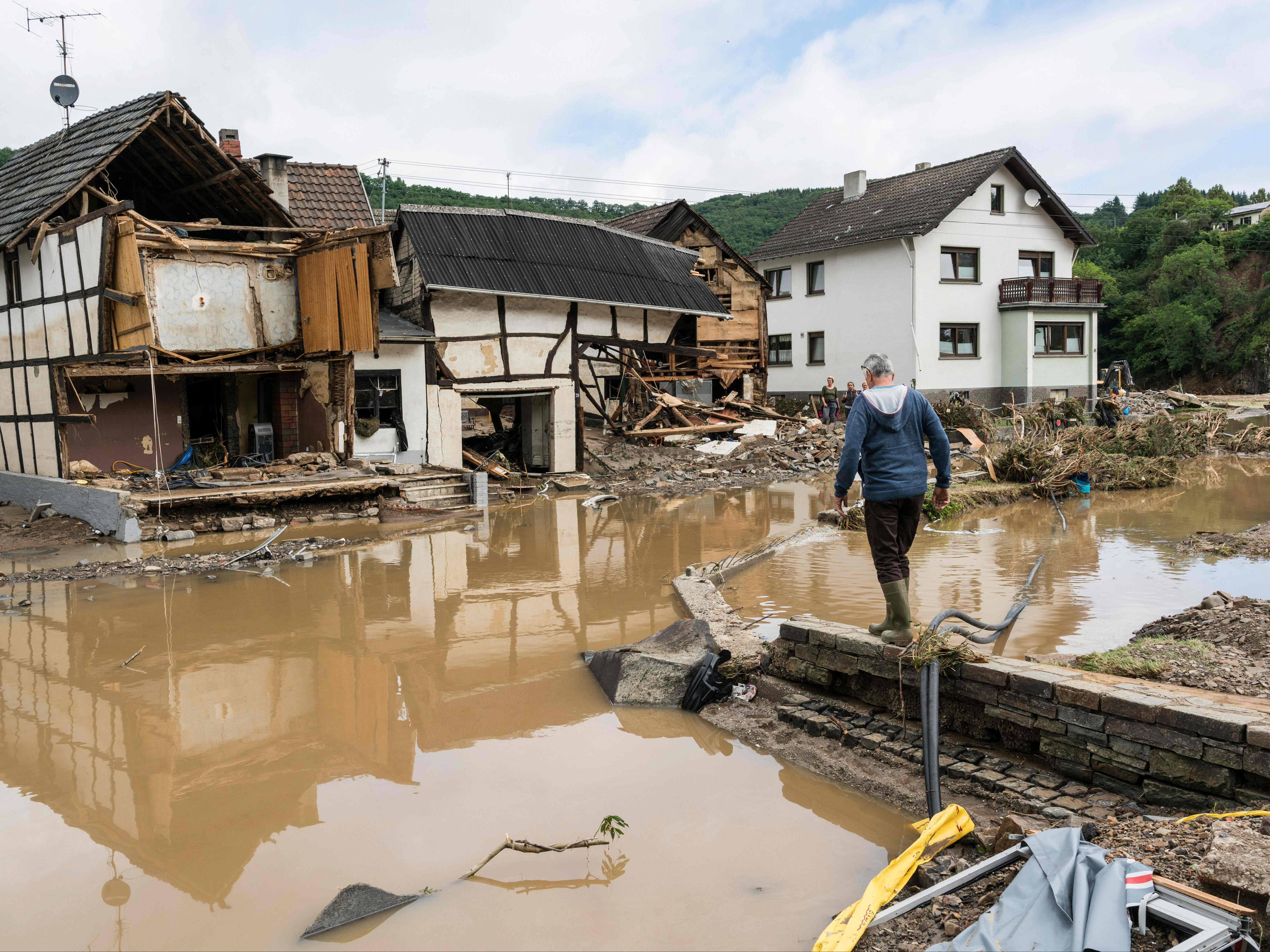 A man walks through the floods towards destroyed houses in Schuld near Bad Neuenahr, western Germany, on July 15, 2021