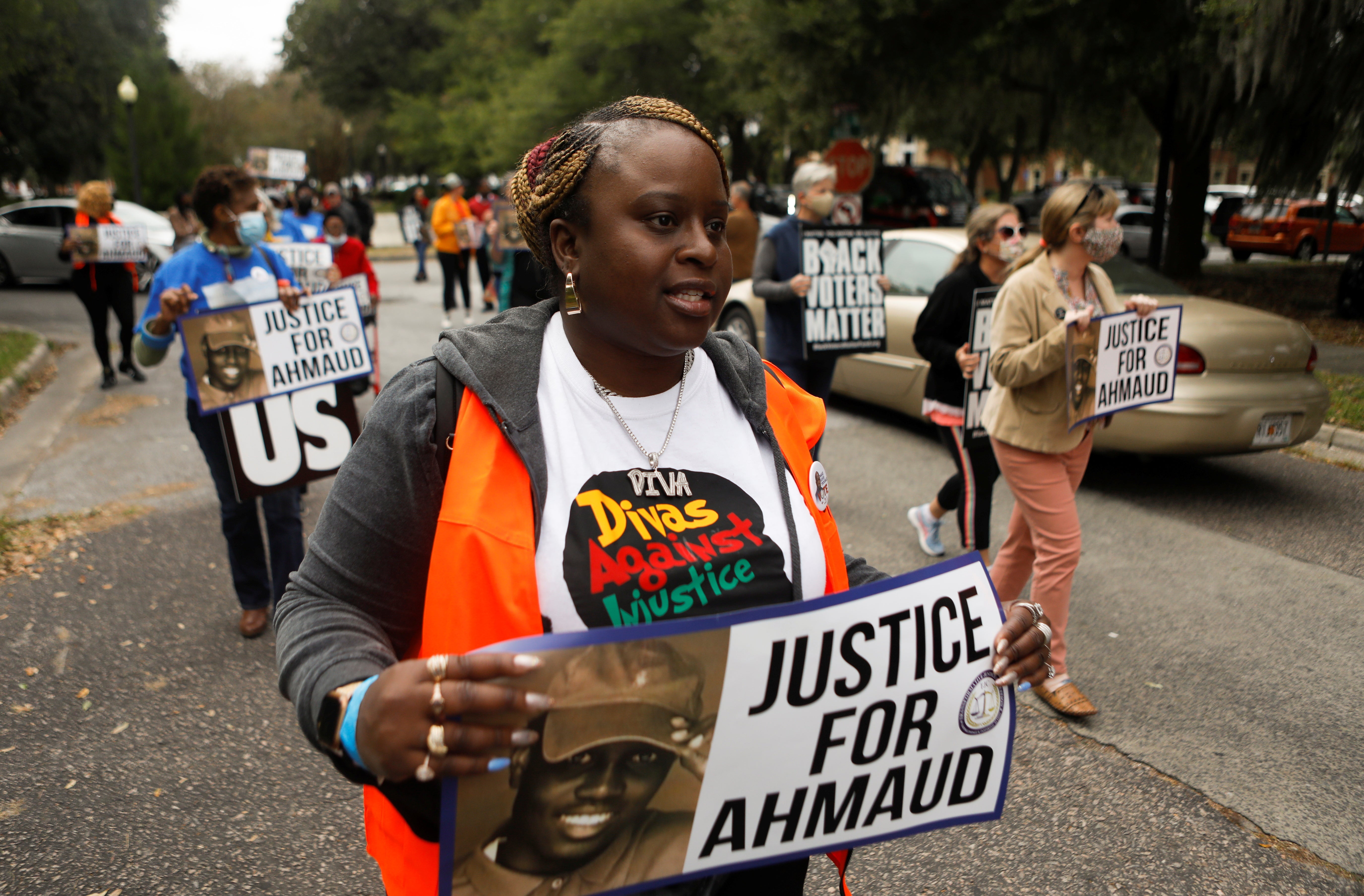 Protesters carry “Justice for Ahmaud” signs through Brunswick, Georgia, on 4 November