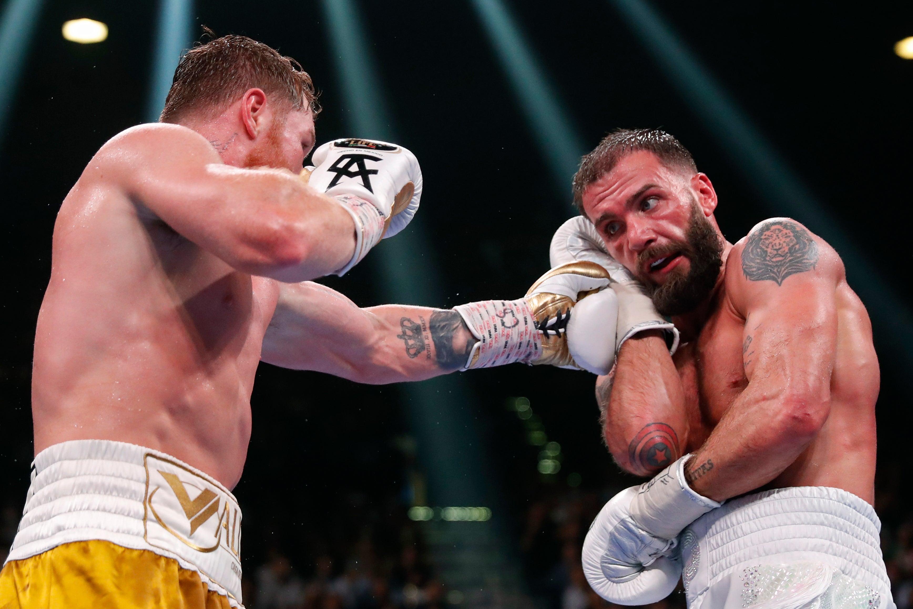 Canelo Alvarez, of Mexico, hits Caleb Plant during a super middleweight title unification fight