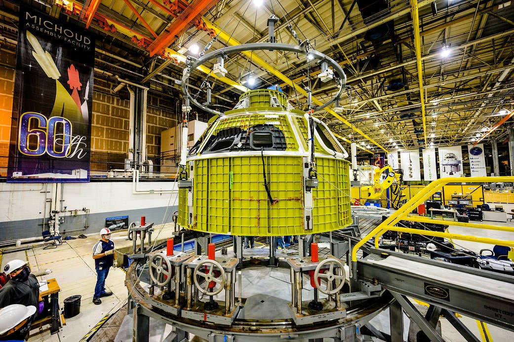 El recipiente a presión recién completado de Orion para la misión Artemis III se saca de la herramienta de soldadura en las instalaciones de ensamblaje Michoud de la NASA en Nueva Orleans.