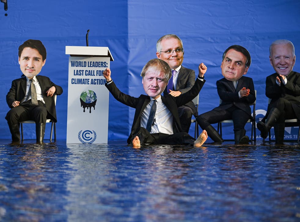 <p>Activistas disfrazados de líderes mundiales se sientan en una balsa en el canal de Forth y Clyde, en protesta por la falta de acción de los gobiernos para reducir las emisiones</p>
