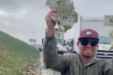 Los conductores se apresuran a recoger el dinero que cayó del camión blindado en la autopista de California