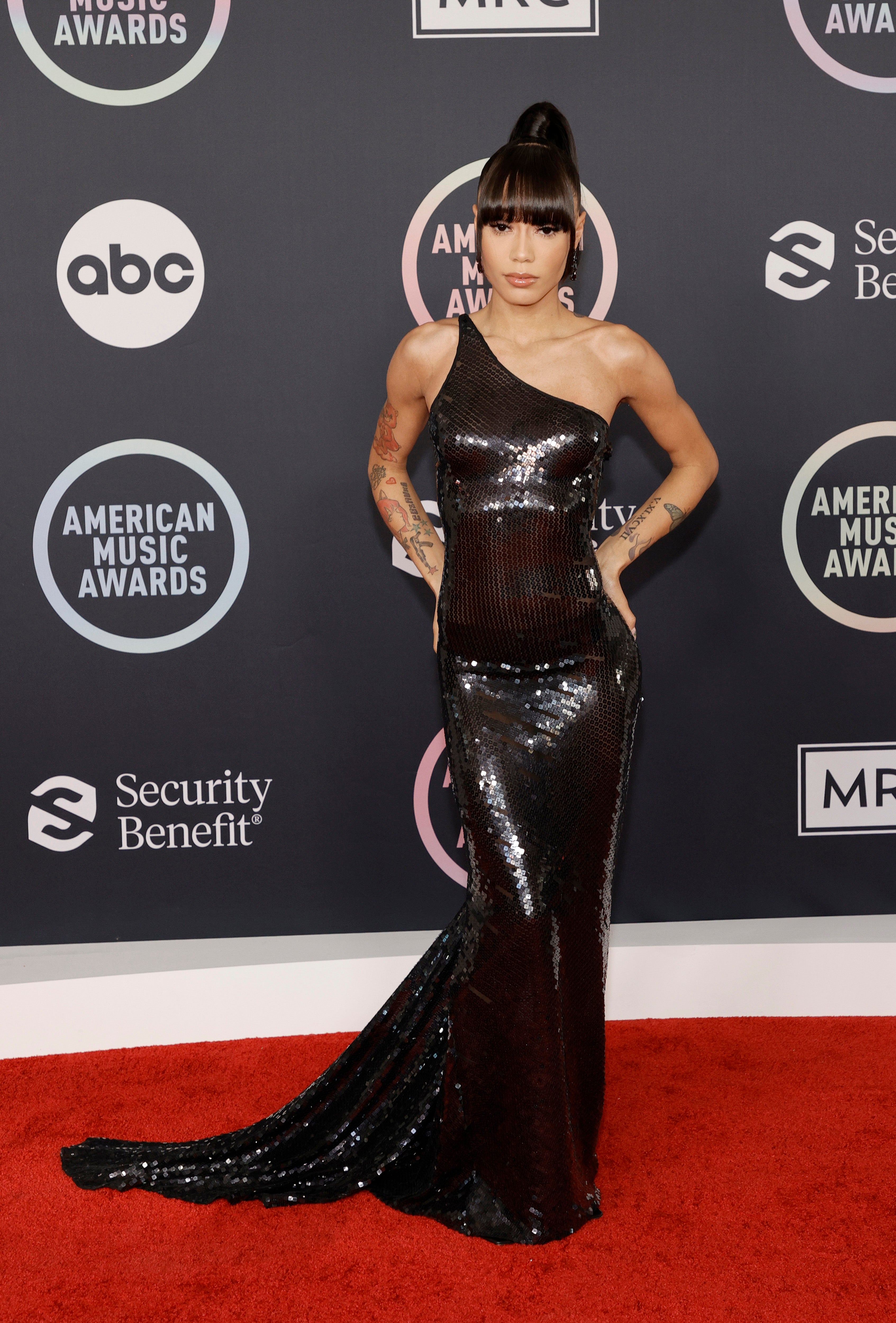 Coi Leray wears a black gown on the AMAs red carpet