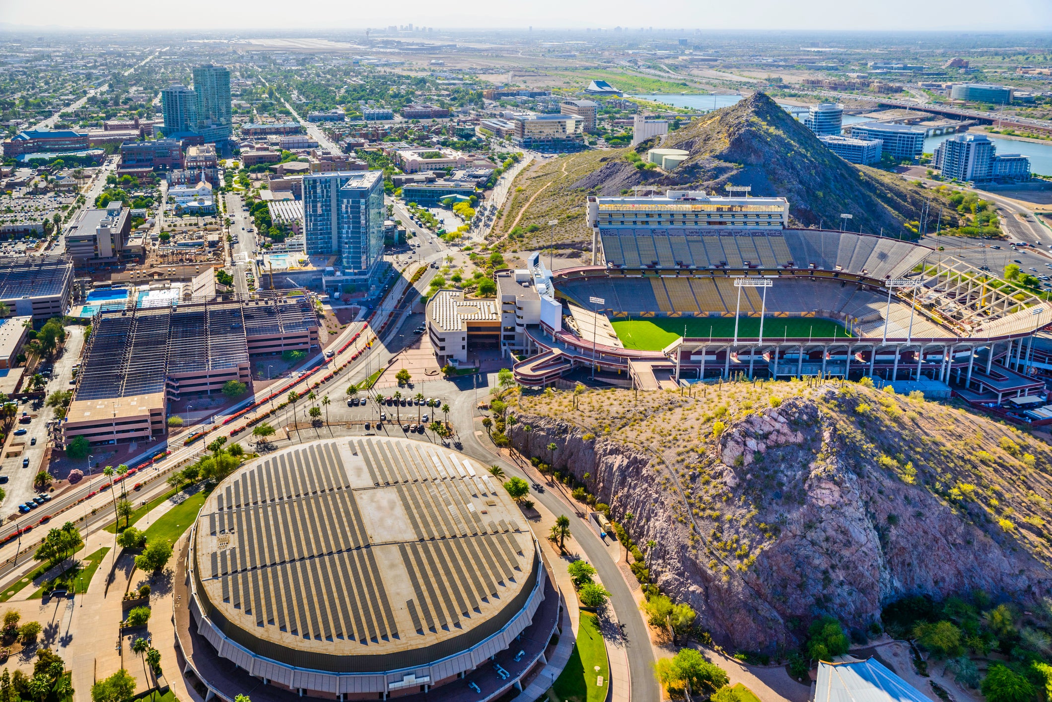 Vista panorámica aérea desde un helicóptero de Tempe, Arizona, que muestra el campus de la Universidad Estatal de Arizona con el estadio de futbol americano Sun Devil (Frank Kush Field) al centro a la derecha