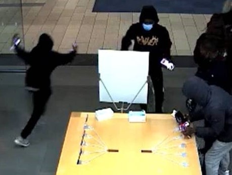 Una imagen granulada de las cámaras de seguridad muestra a cuatro jóvenes con capucha y pantalones vaqueros en pleno robo
