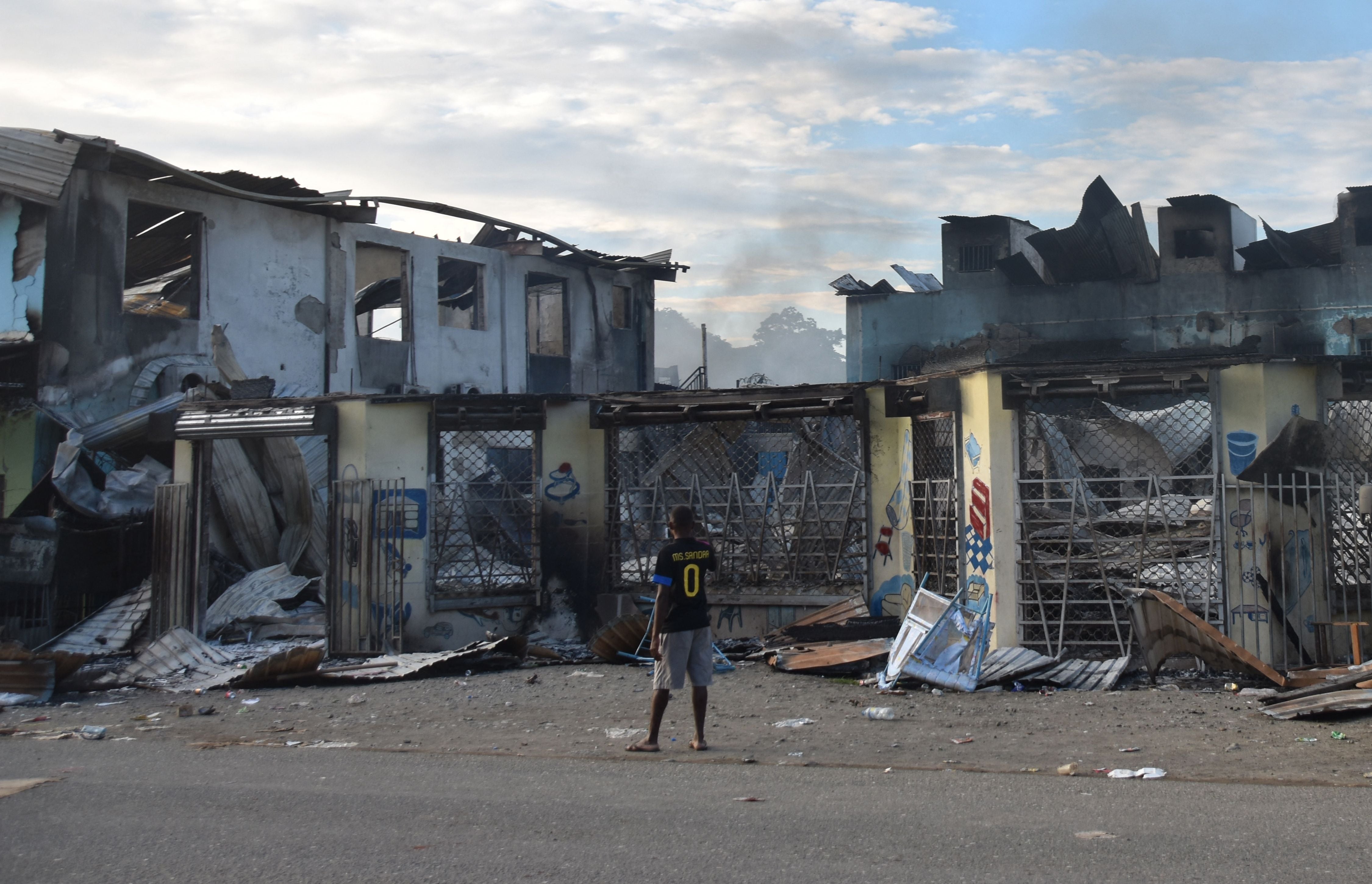 Foto de archivo: un hombre observa los daños causados por los disturbios en Honiara, Islas Salomón, el 27 de noviembre de 2021