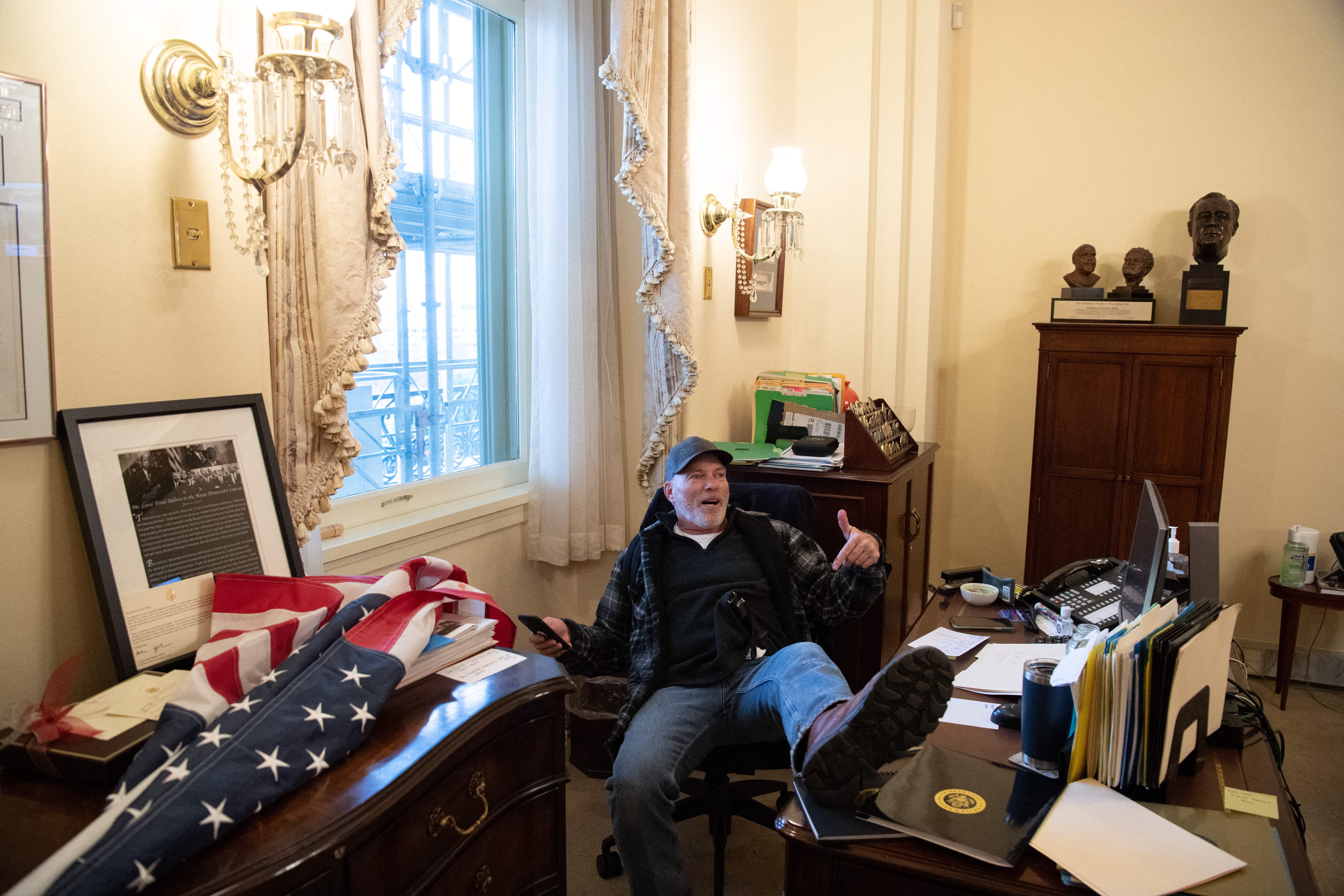 Richard Barnett, partidario del presidente de los EE.UU. Donald Trump se sienta en la oficina de la presidenta de la Cámara Nancy Pelosi.