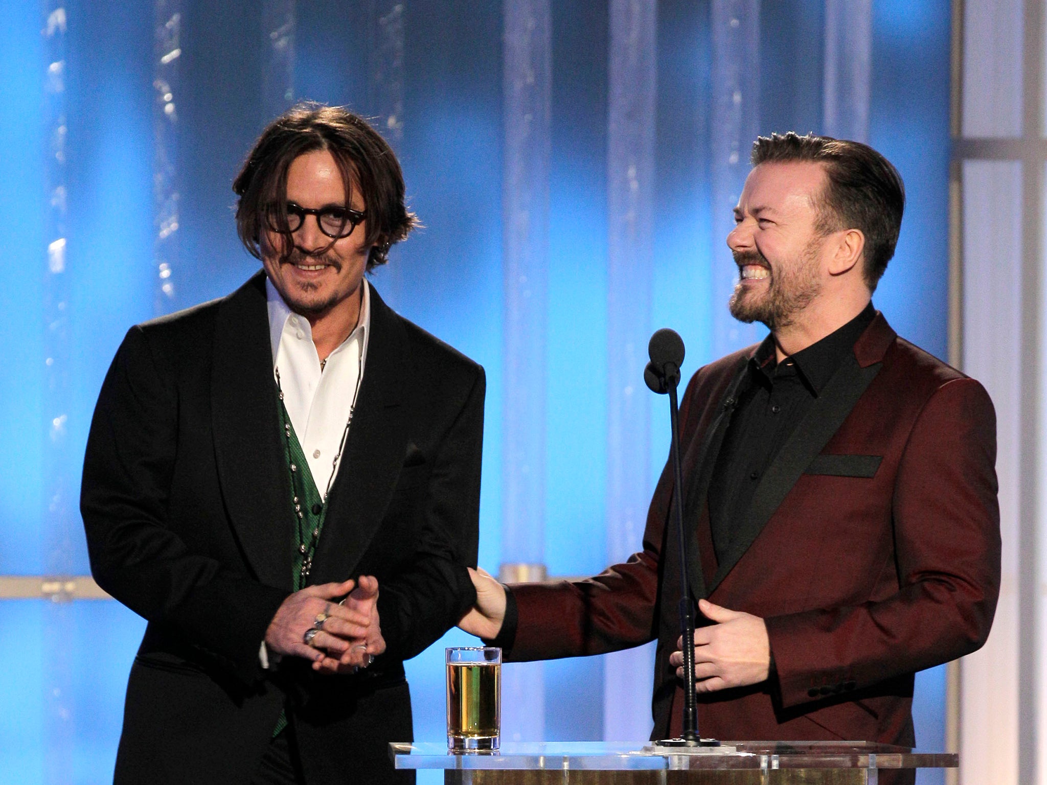 El nominado a The Tourist , Johnny Depp, y el presentador recurrente de los Globos de Oro, Ricky Gervais, en los premios de 2012