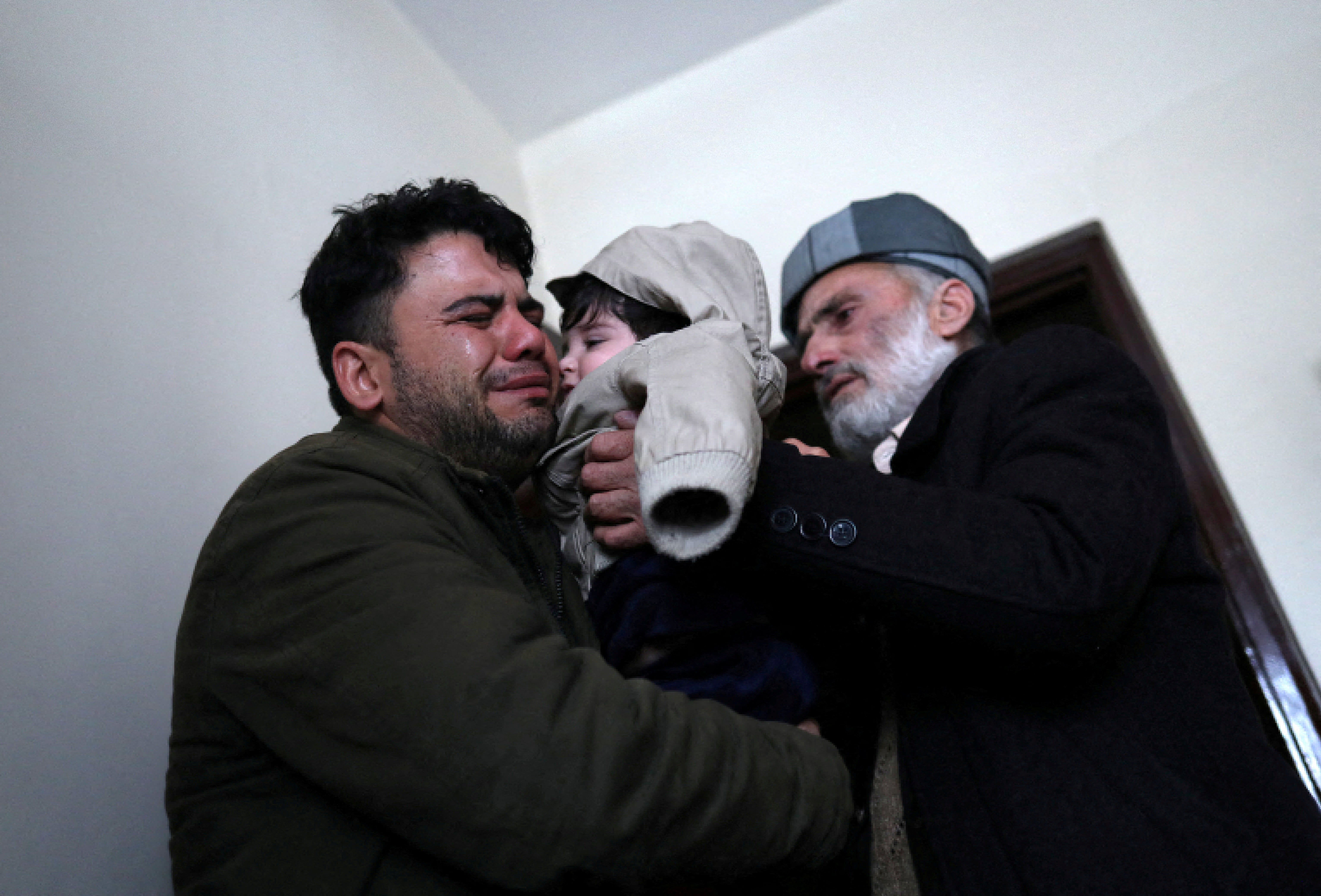Hamid Safi llora mientras carga a Sohail y se lo entrega a su abuelo Mohammad Qasem Razawi en Kabul