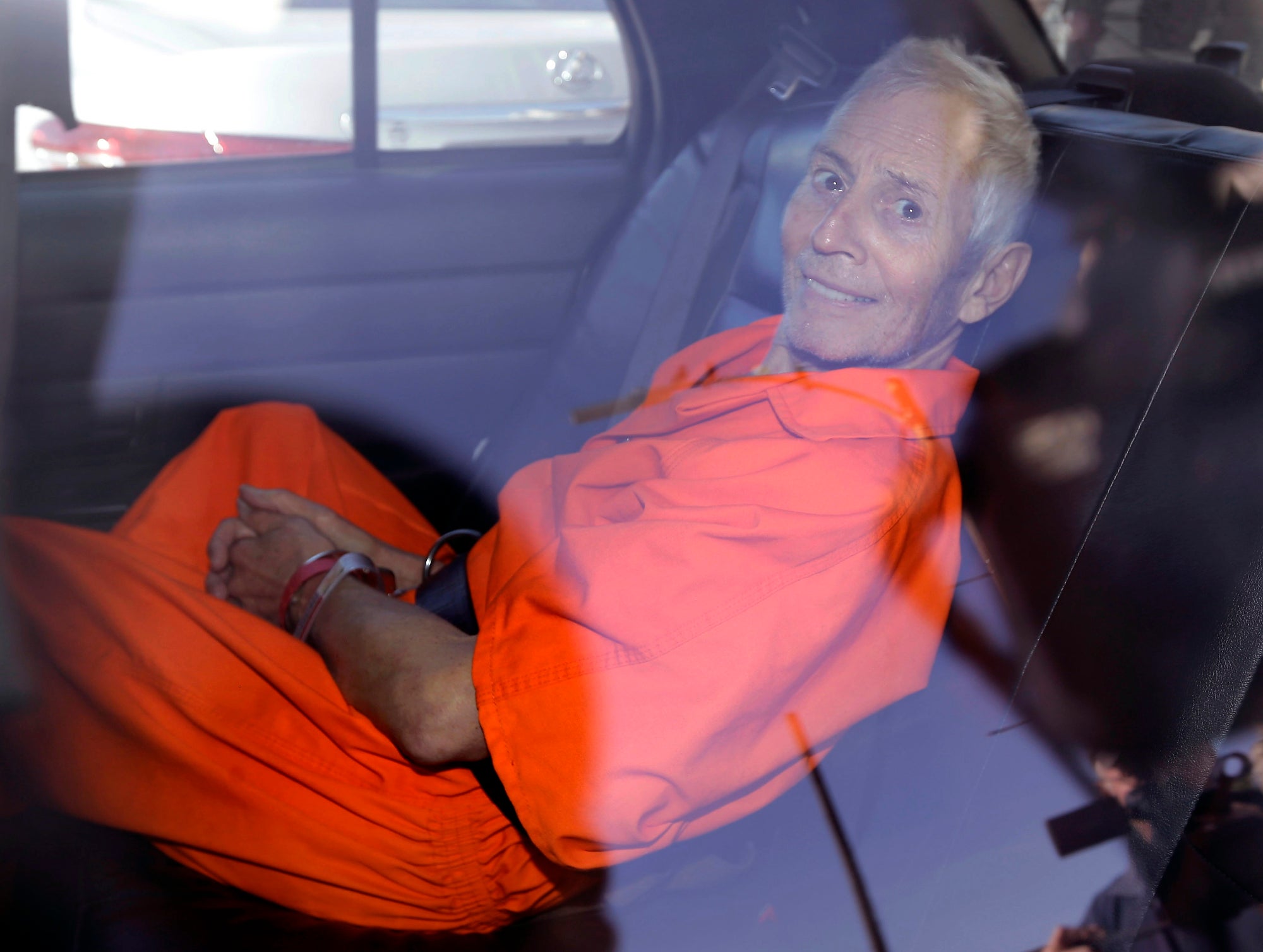 Robert Durst vestido con el uniforme de la prisión sonríe después de haber sido arrestado por el asesinato de Susan Berman en 2015