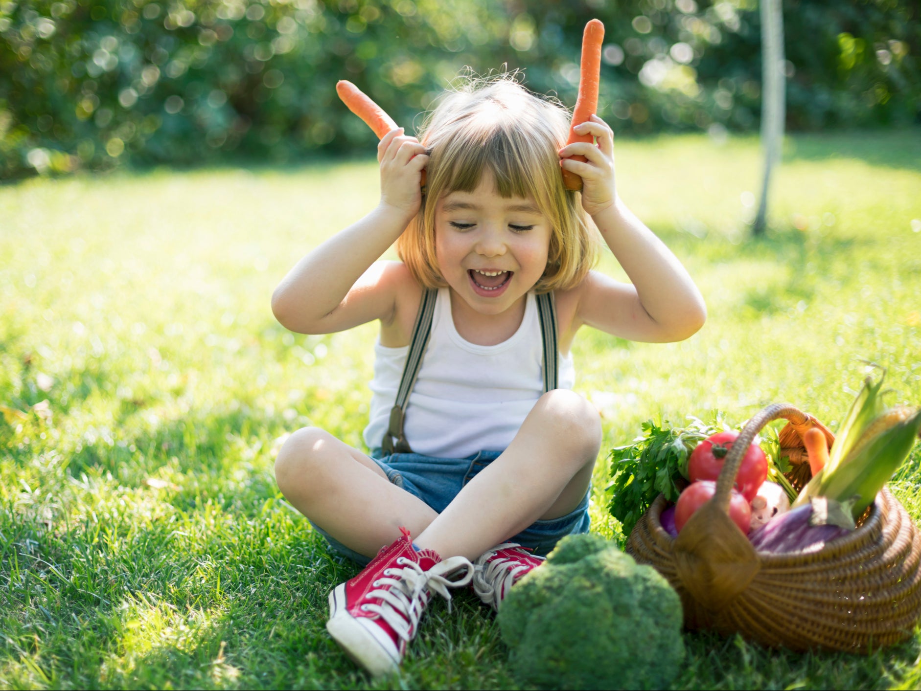 <p>Una niña con una cesta de verduras</p>