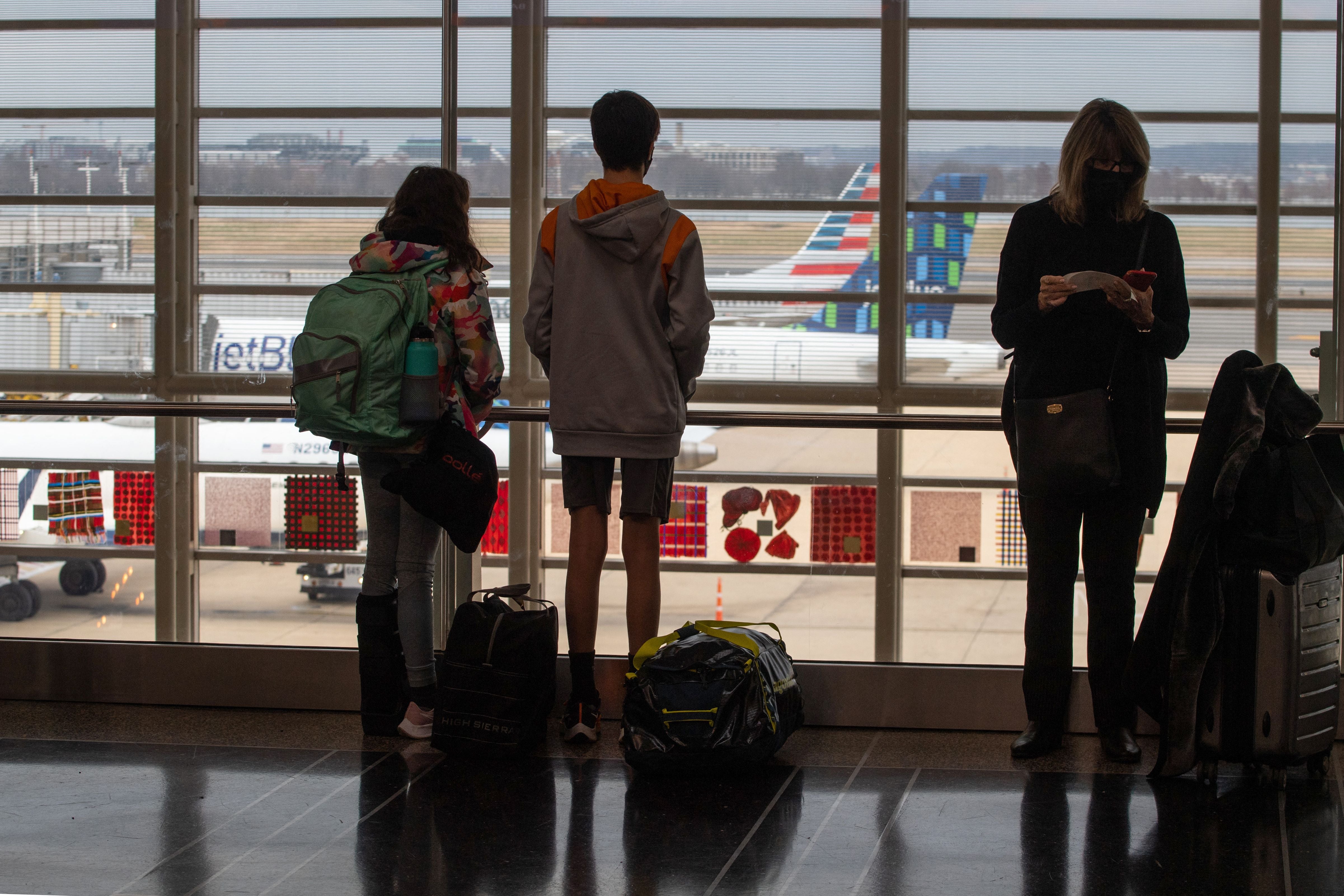 Archivo: Viajeros observan aviones en la pista, cerca de los mostradores de documentación en el Aeropuerto Internacional Ronald Reagan de Washington D. C. el 27 de diciembre de 2021