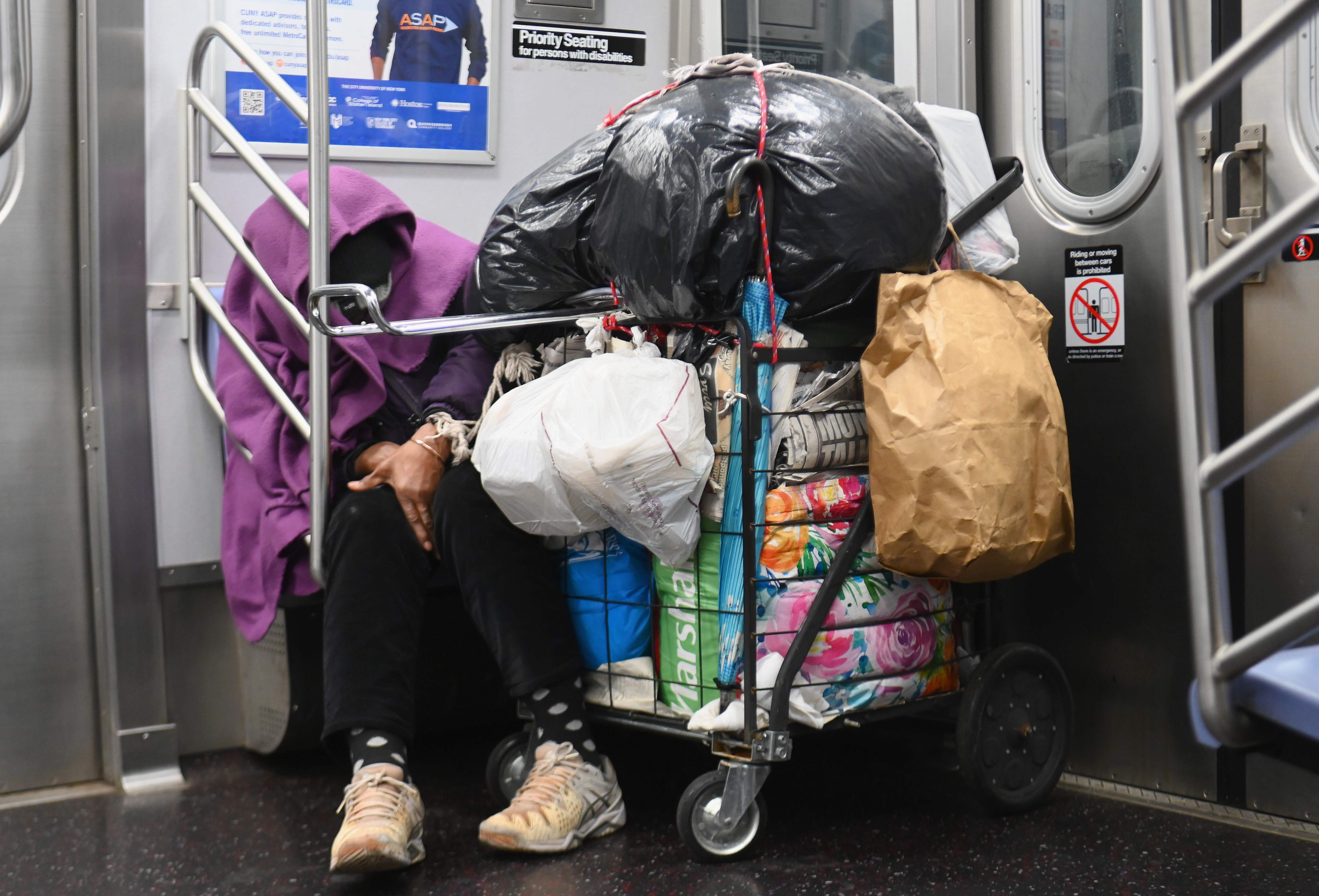 Una persona sin hogar duerme en un vagón de metro de Nueva York