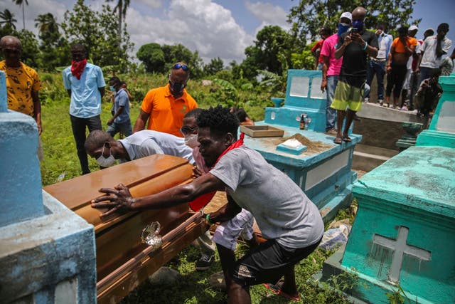 <p>Hombres colocan ataúd con los restos de Francois Elmay en una tumba tras recuperar su cuerpo de los escombros de una casa destruida cuatro días antes por un terremoto de magnitud 7,2 en 2021</p>