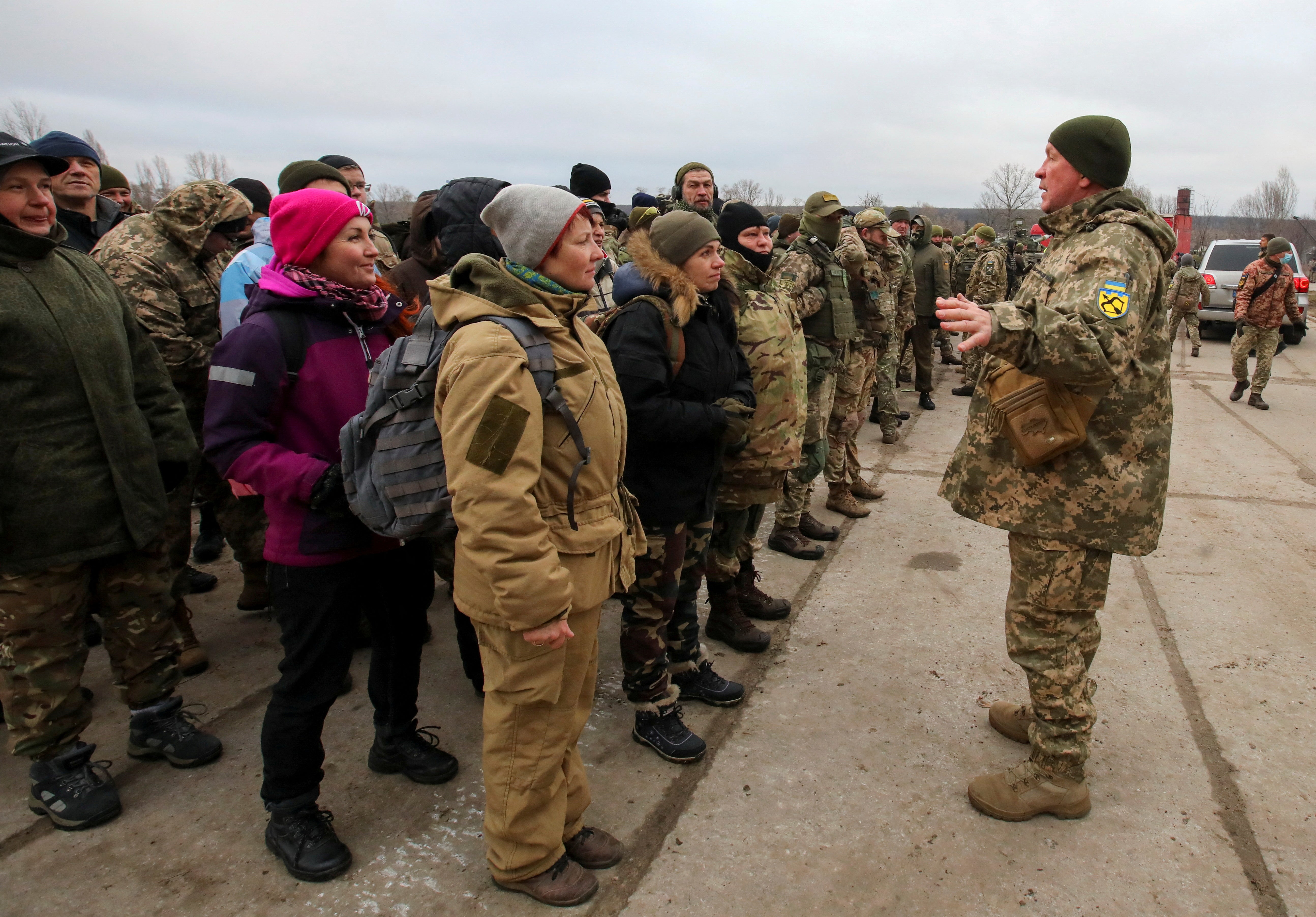 Reservistas de las Fuerzas de Defensa Territorial de Ucrania escuchan instrucciones durante los ejercicios militares en un campo de entrenamiento a las afueras de Kharkiv