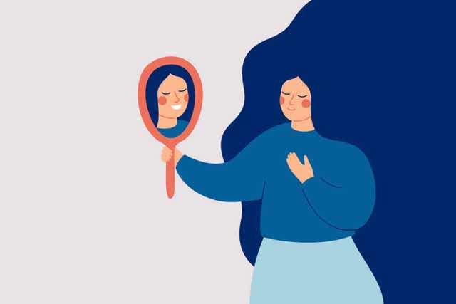 <p>La mujer joven mira el espejo y ve su reflejo feliz. Concepto de autoaceptación y confianza. </p>