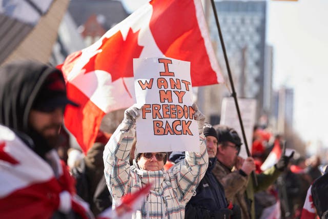 Un manifestante sostiene un cartel durante una protesta en el centro de Toronto, Ontario, el sábado.