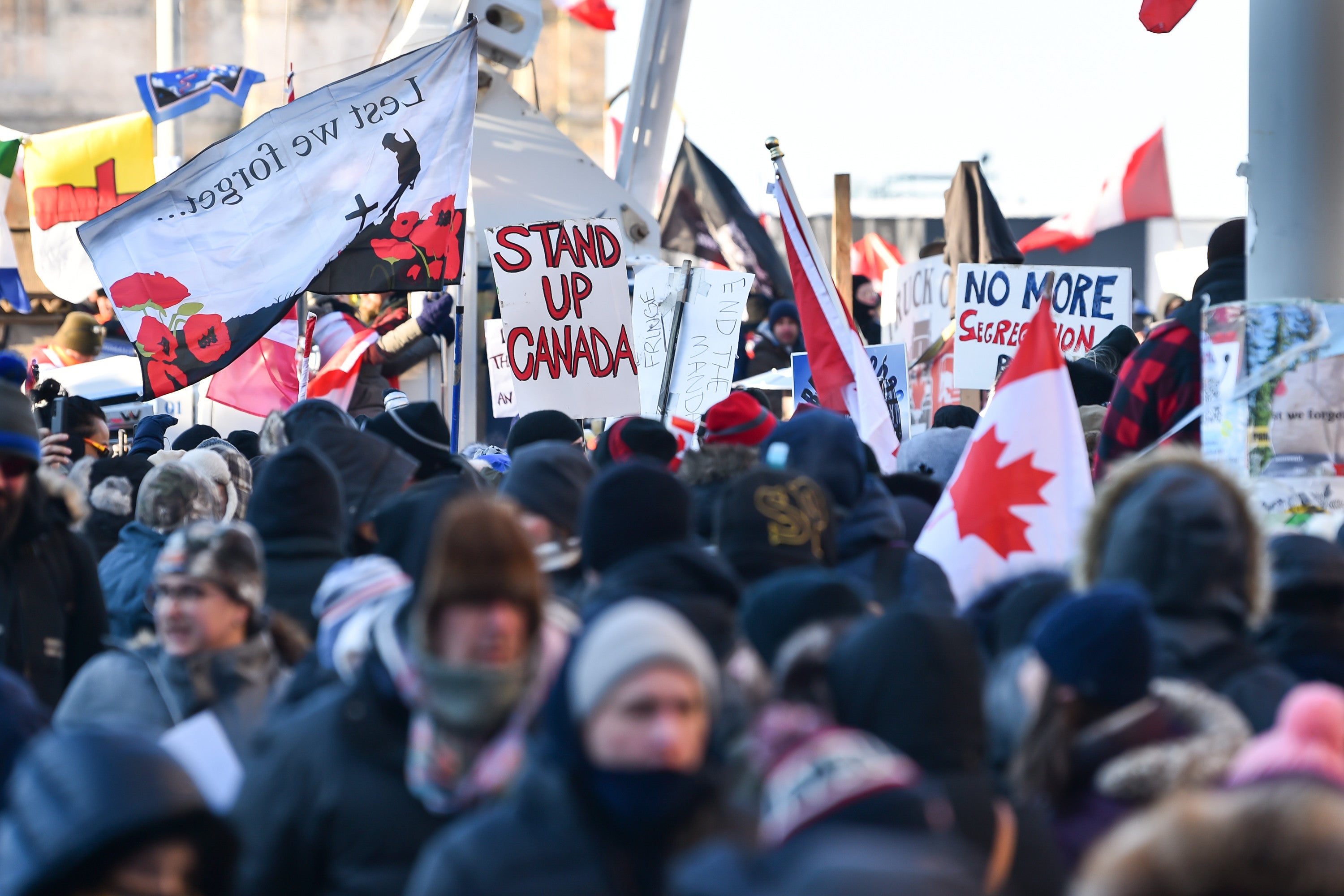 Miles de manifestantes se aglomeraron cerca de Parliament Hill en Ottawa el sábado con pancartas que criticaban los mandatos de vacunación