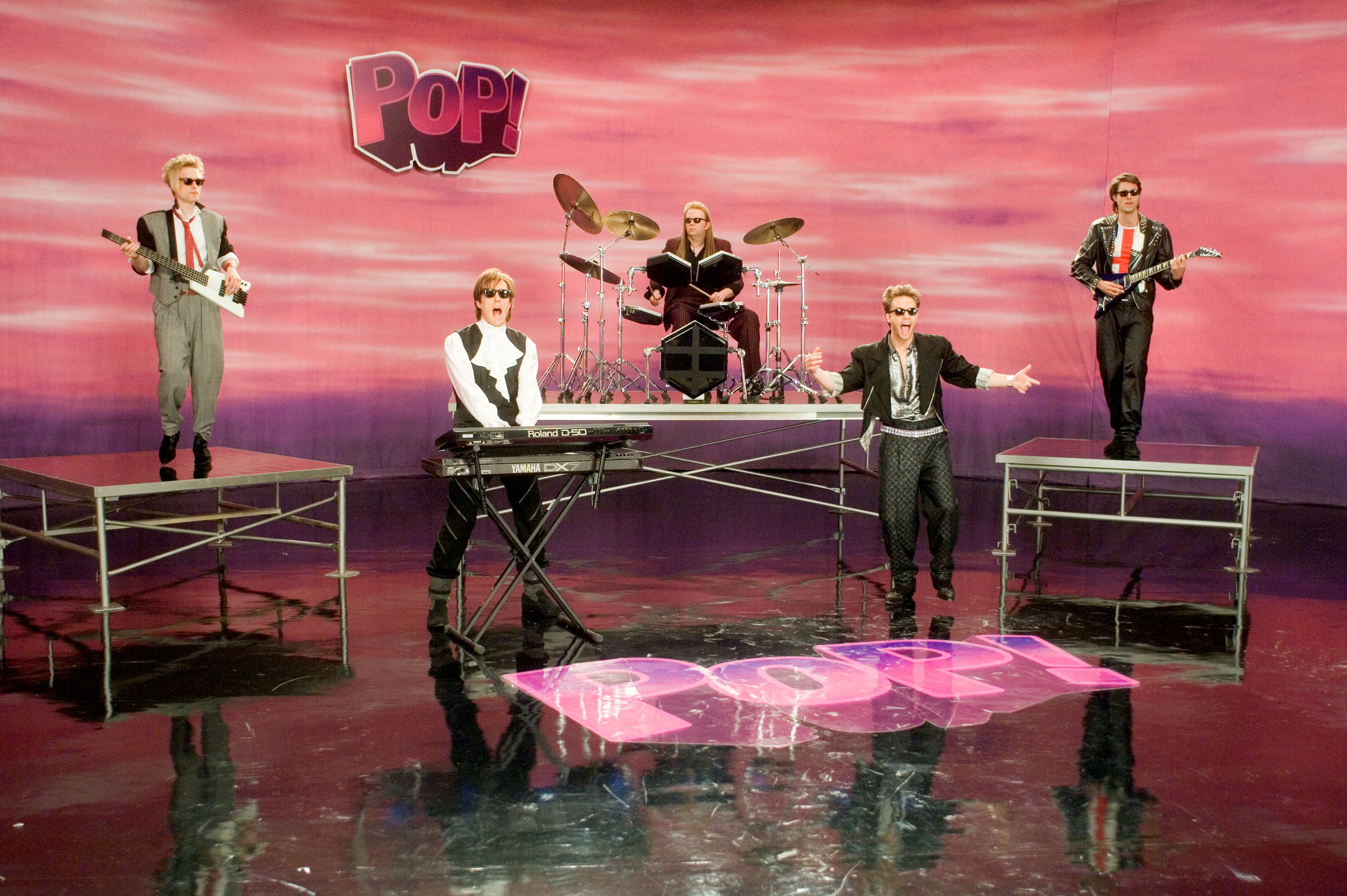 Hugh Grant (el segundo de izquierda a derecha) con el grupo de pop ficticio PoP! en el vídeo musical de “Pop Goes My Heart”
