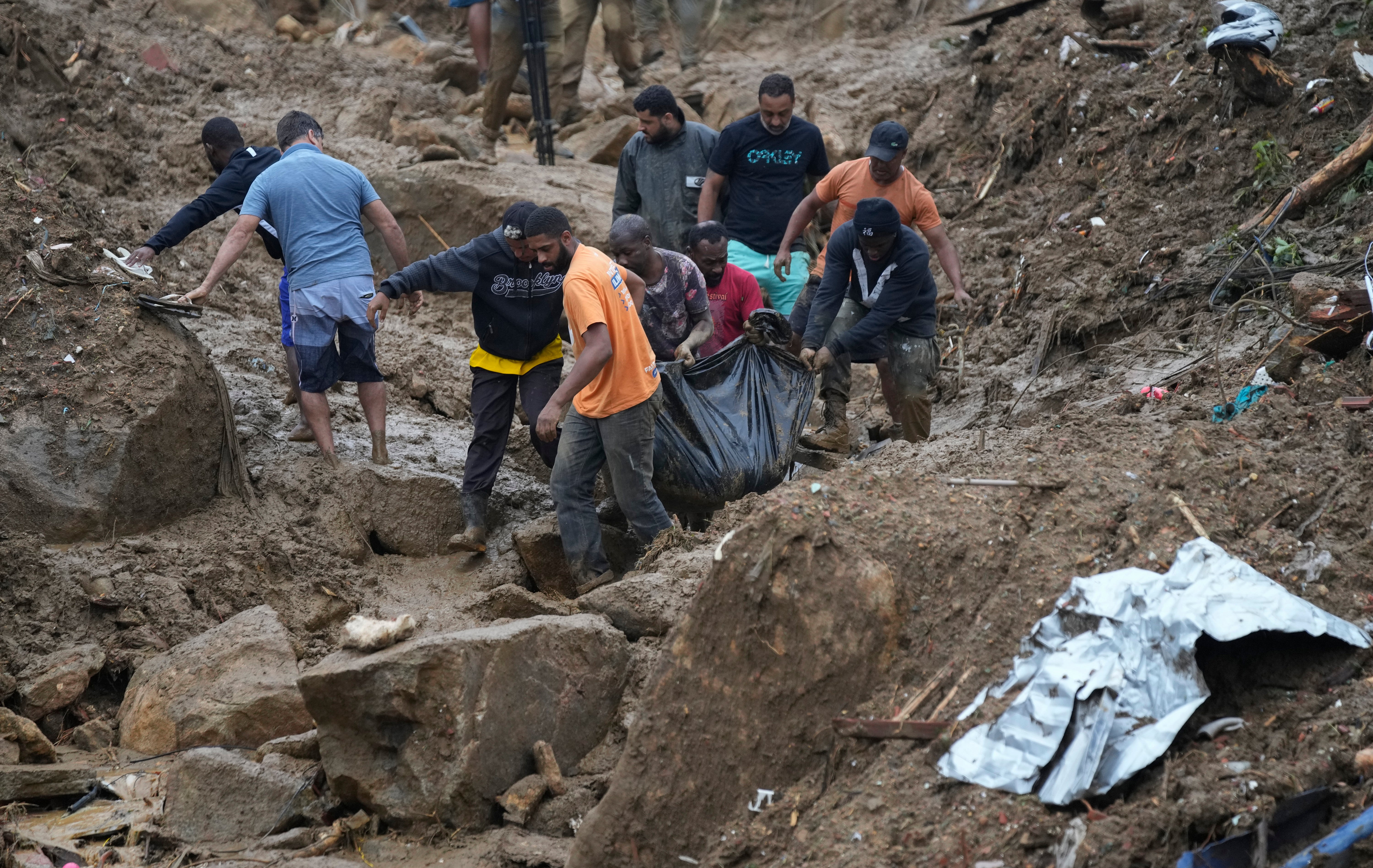 Residentes y voluntarios retiran el cuerpo de una víctima de deslaves en Petrópolis, Brasil. Los deslaves provocaron la muerte de varias personas, informaron las autoridades
