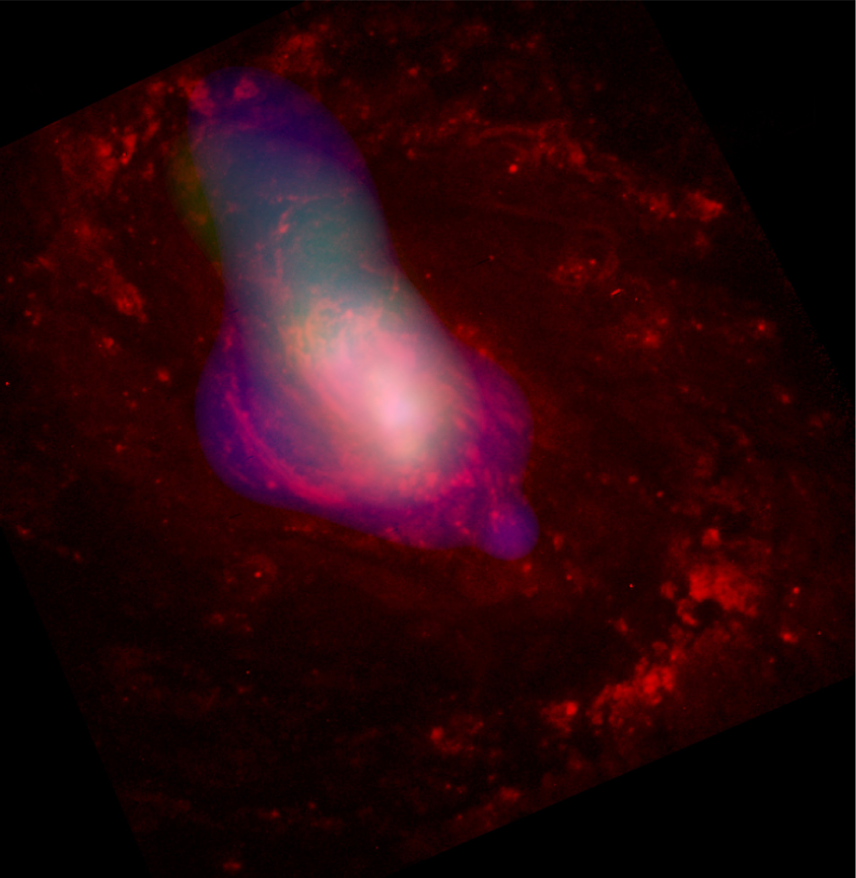 Una nube de gas blanco es alejada del centro de la galaxia activa Messier 77, presumiblemente por el agujero negro supermasivo que se esconde en su centro