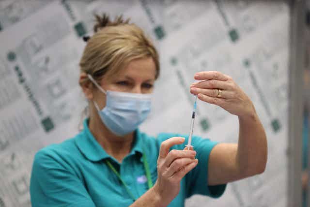 <p>A vaccinator prepares vaccines at a booster centre in Belfast (PA)</p>