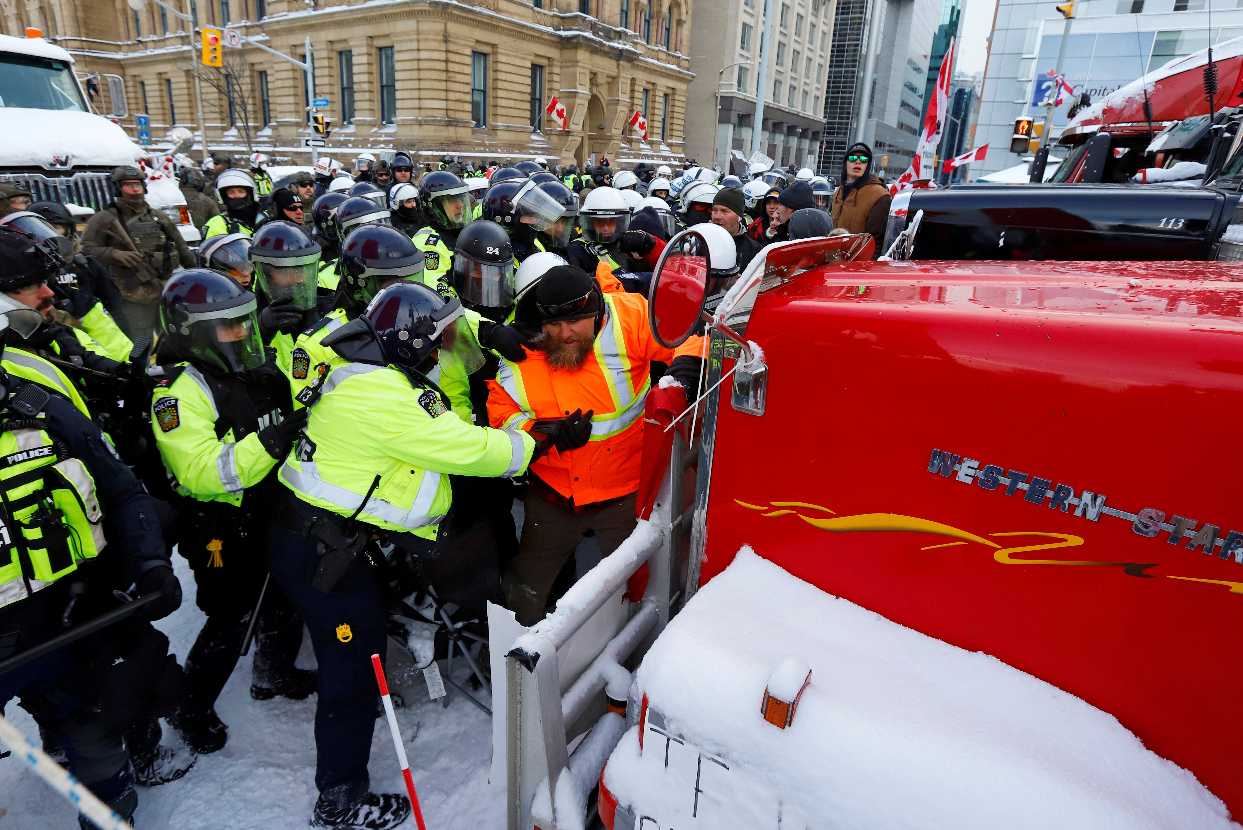 La policía canadiense empuja a un manifestante contra un camión frente a la Colina del Parlamento mientras la policía trabaja para restablecer la normalidad en la capital mientras los camiones y los manifestantes siguen ocupando el centro de la ciudad para protestar por las restricciones del covid-19 en Ottawa, Ontario, Canadá, el 19 de febrero de 2022. REUTERS/Patrick Doyle