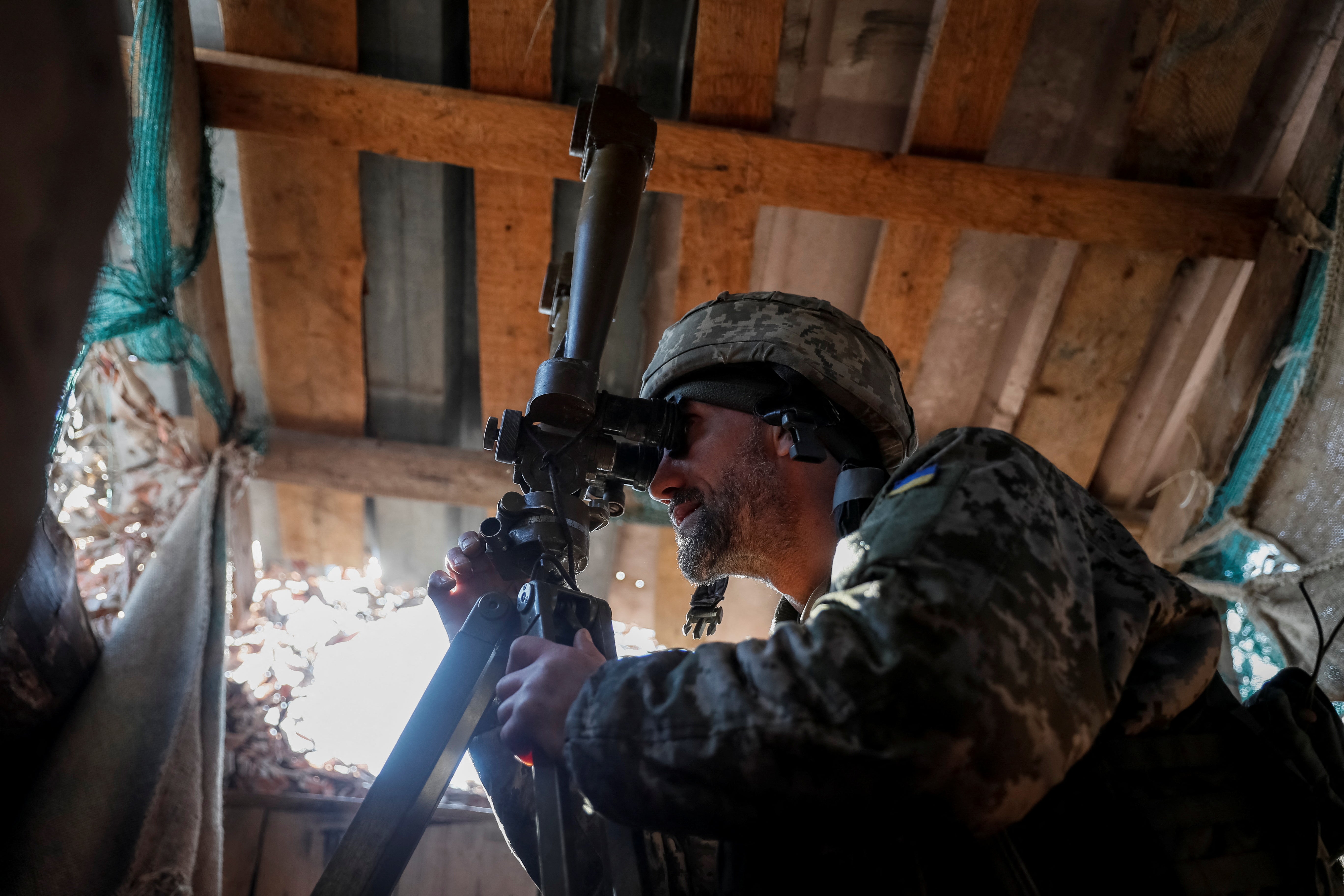Un miembro del servicio militar Ucraniano utiliza un periscopio para observar el área en un sitio cerca de la primera línea en la villa de Travneve en la región de Donetsk