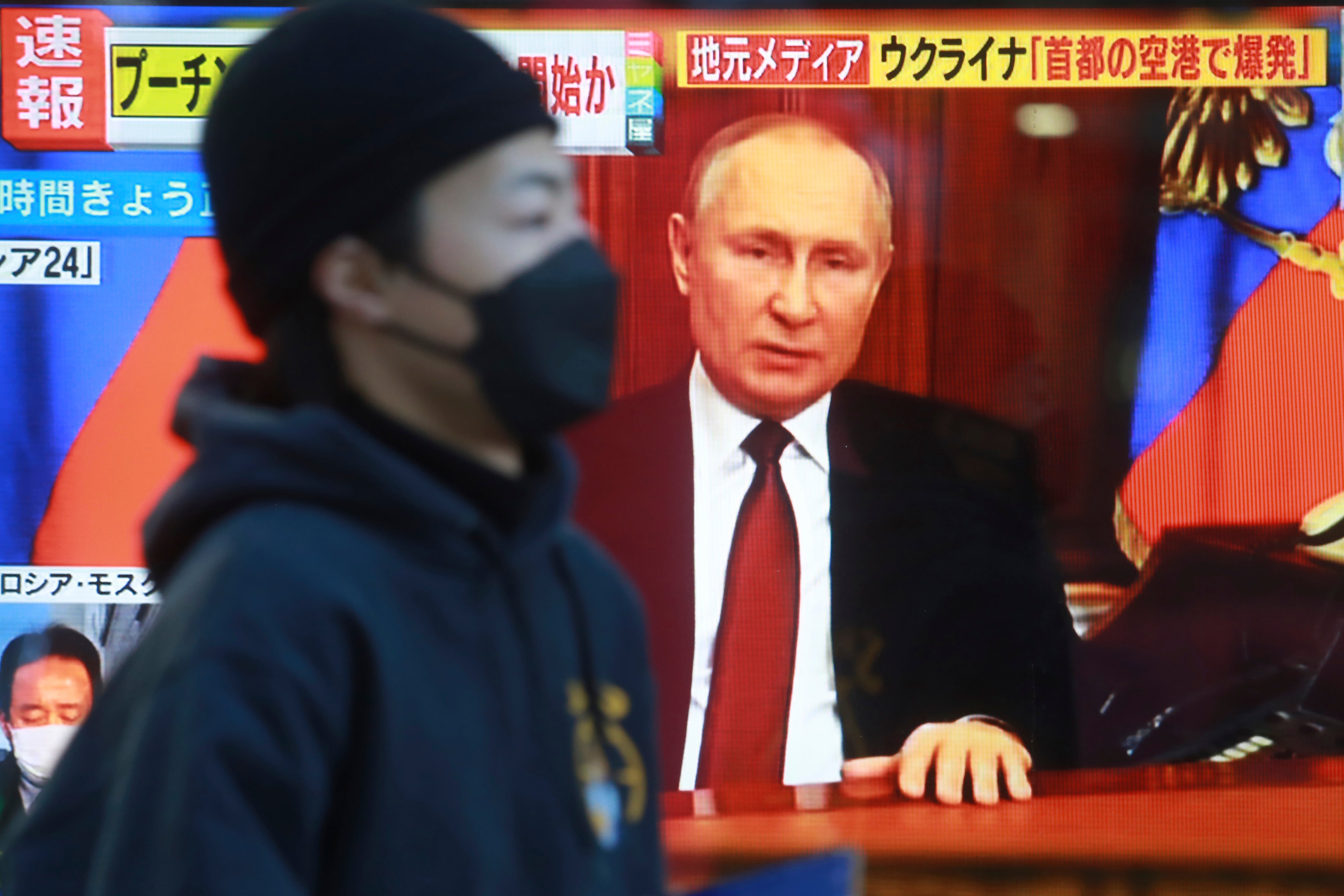 Archivo: un hombre pasa por delante de una pantalla de televisión con la imagen del presidente de Rusia, Vladimir Putin, en Tokio, el jueves 24 de febrero de 2022