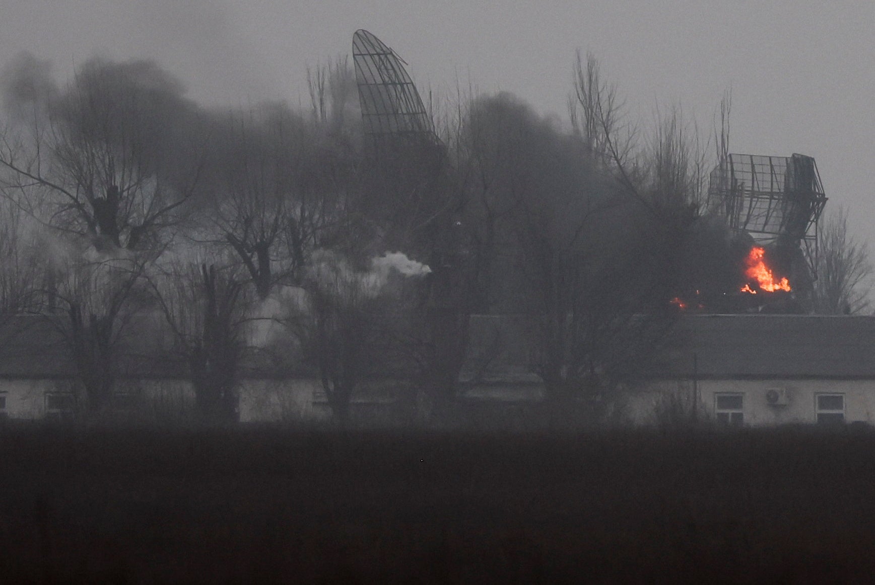 Se ve fuego saliendo de una instalación militar cerca del aeropuerto, después de que el presidente ruso Vladimir Putin autorizara una operación militar en el este de Ucrania, en Mariupol