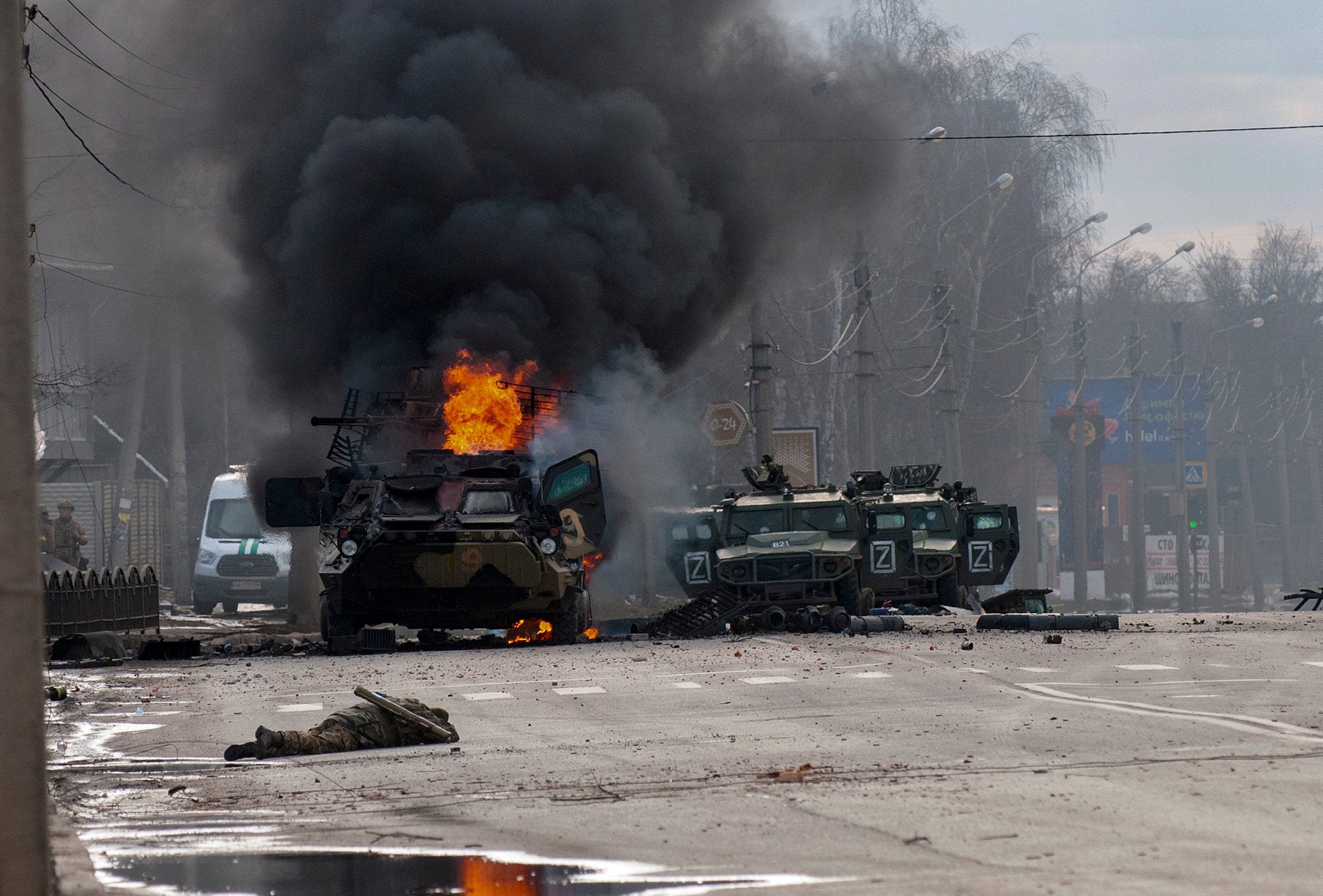 Un transporte blindado de tropas se incendia y los vehículos militares ligeros descompuestos se quedan abandonados después de pelear en Járkov, Ucrania, el domingo 27 de febrero de 2022
