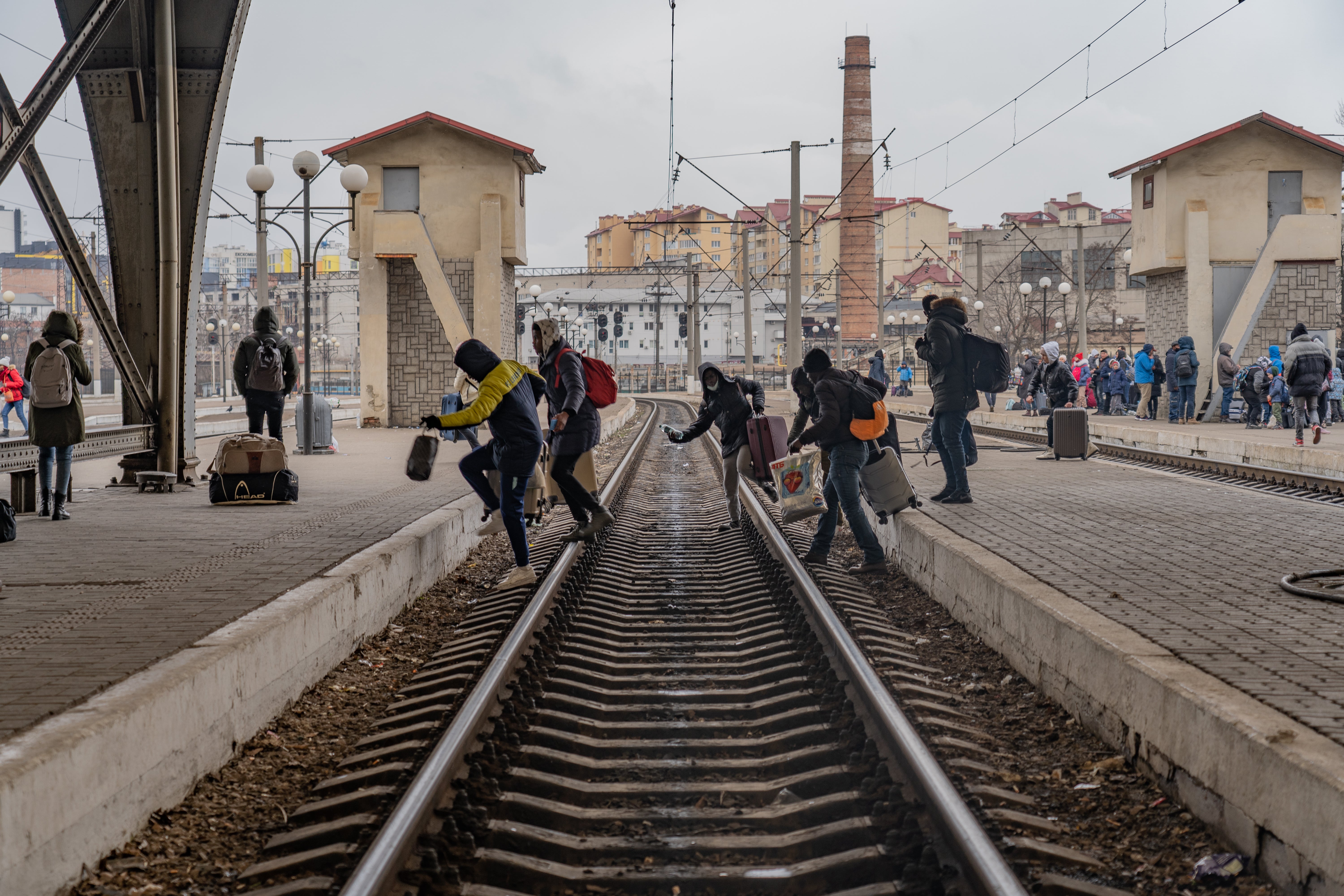 Un grupo de refugiados nigerianos atraviesan las plataformas en una estación, esperando poder abordar un tren